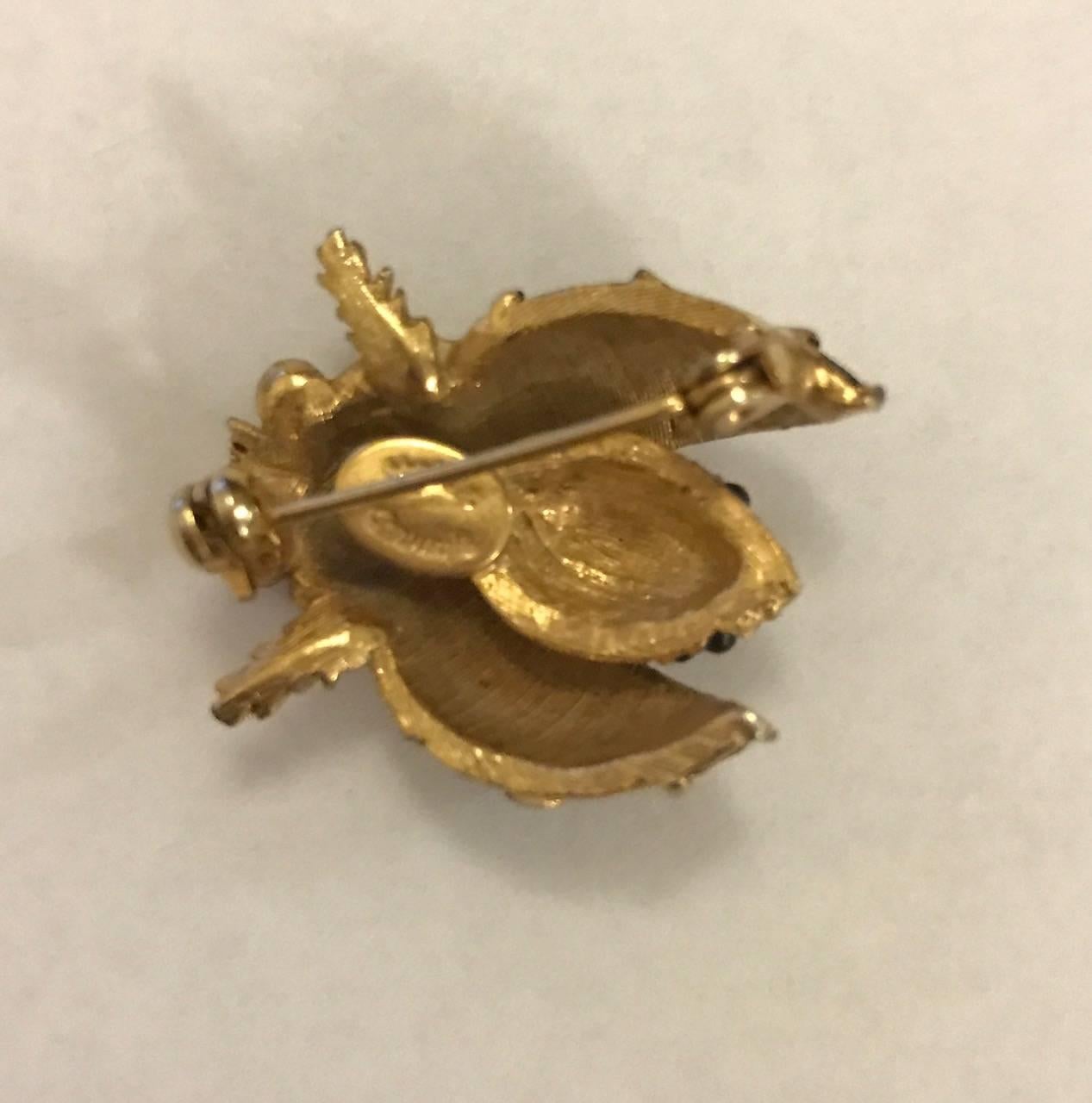 Hattie Carnegie signed vintage (1960's?) gold tone insect pin with enamel and glass detailing. Beautifully made with intricate detailing. Wear alone or embrace one of this season's biggest trends by clustering with others on your coat lapel.