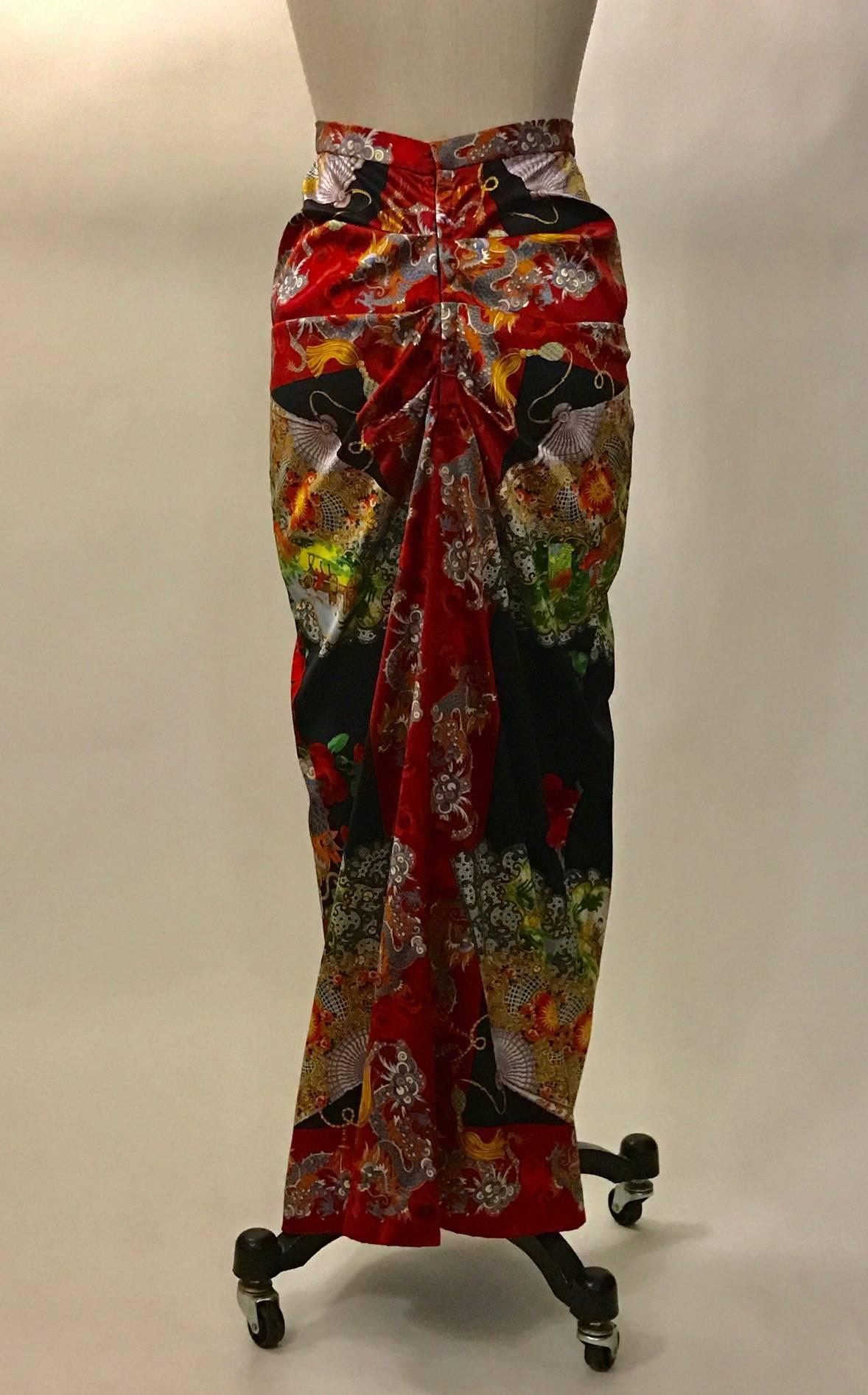 Dolce and Gabbana silk blend skirt features an Asian inspired print featuring dragons, roses and fans depicting countryside scenes. Amazing ruched detailing at back. Closes at back with ten hook and eyes and a snap. Eight inch slit at back center
