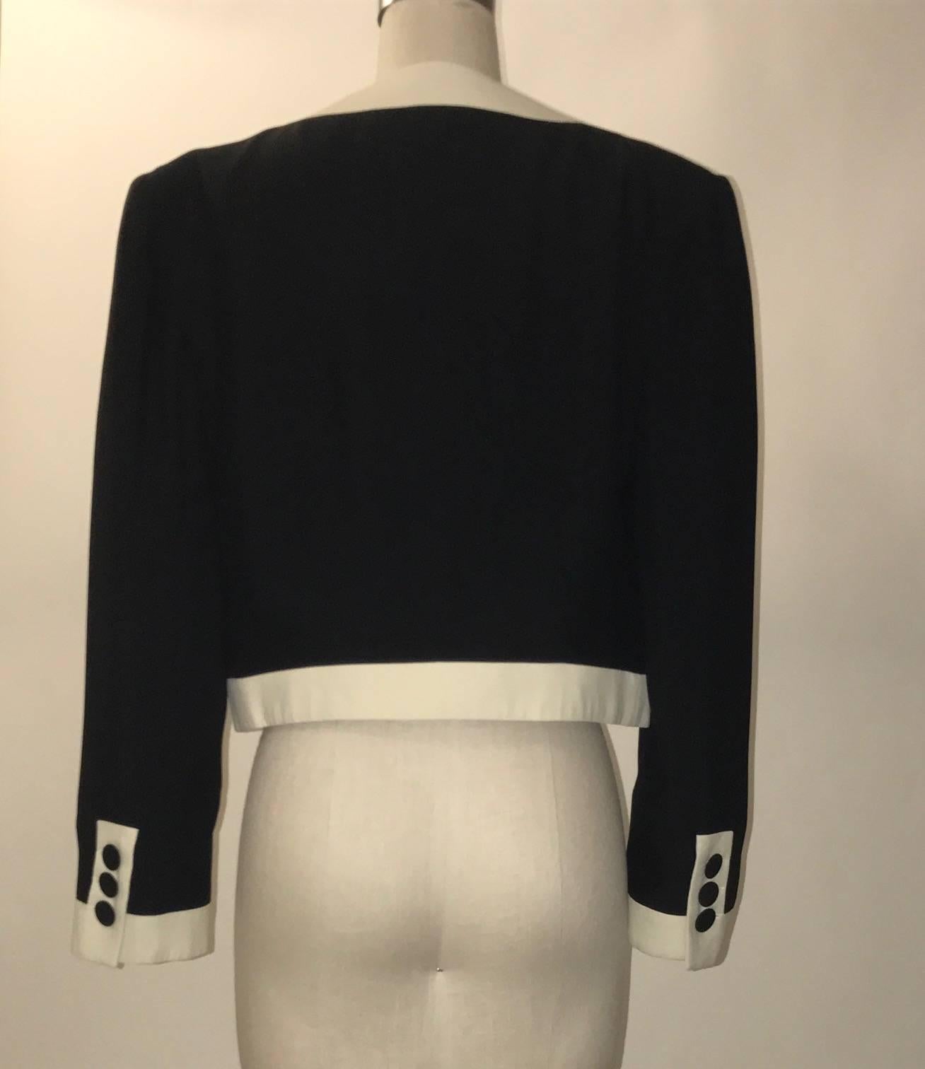 Moschino Couture 1990s black and white jacket with contrast trim and faux drawers with button drawer pulls at front. A cheeky nod to the drawer bodice designs by Dali and Schiaparelli. Open front. Buttons at cuffs.

55% acetate, 45% rayon.
Fully