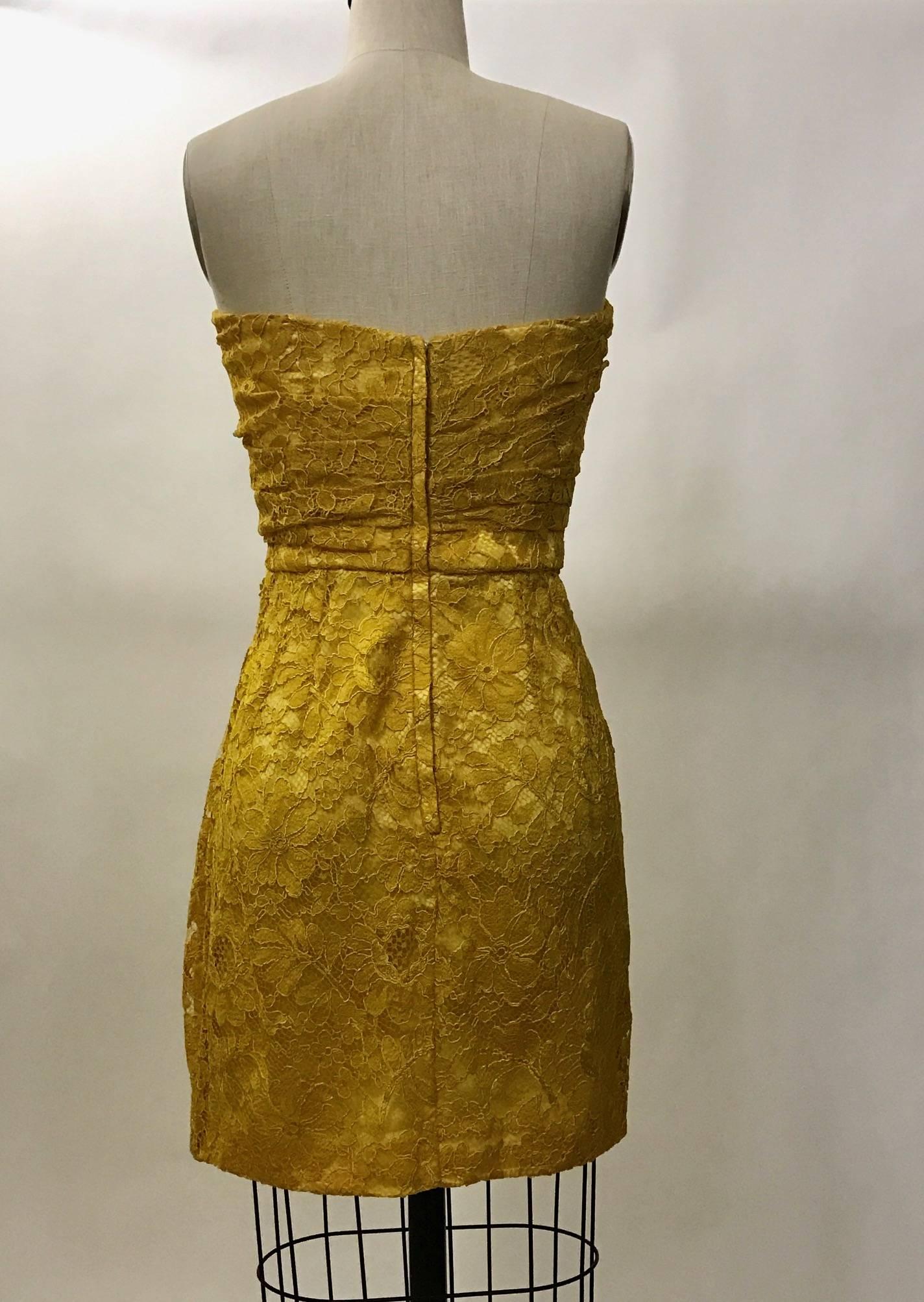 Dolce & Gabbana floral lace strapless dress in a rich marigold yellow tone.  Slight ruching at right waist creates a curvy silhouette. Boning and cups built into bodice. Back zip. 

Lace: 75% viscose, 25% polyamide.
Fully lined in 97% silk, 3%