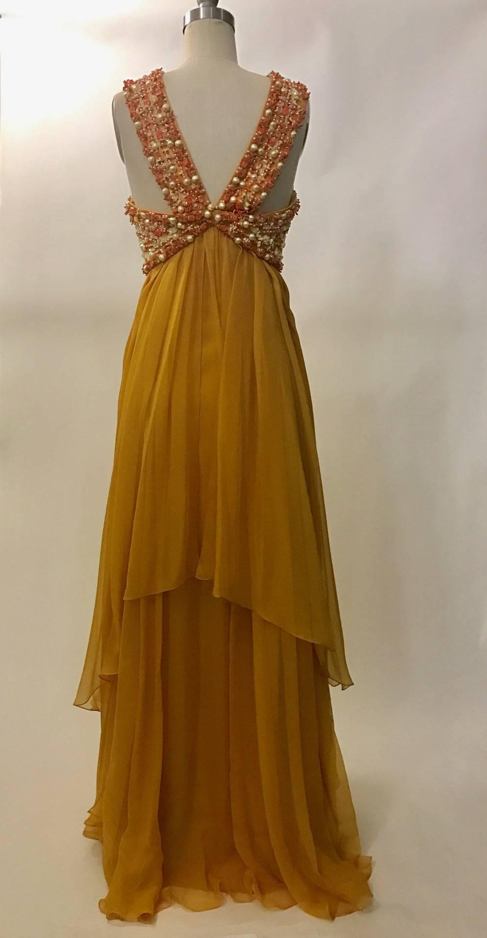 Christian Dior by John Galliano halterneck marigold yellow flowing layered chiffon gown with beaded embroidery featuring sequins interspersed with imitation pearls and coral. Empire waist. Side zip with snaps fastening top layer of chiffon.

Resort