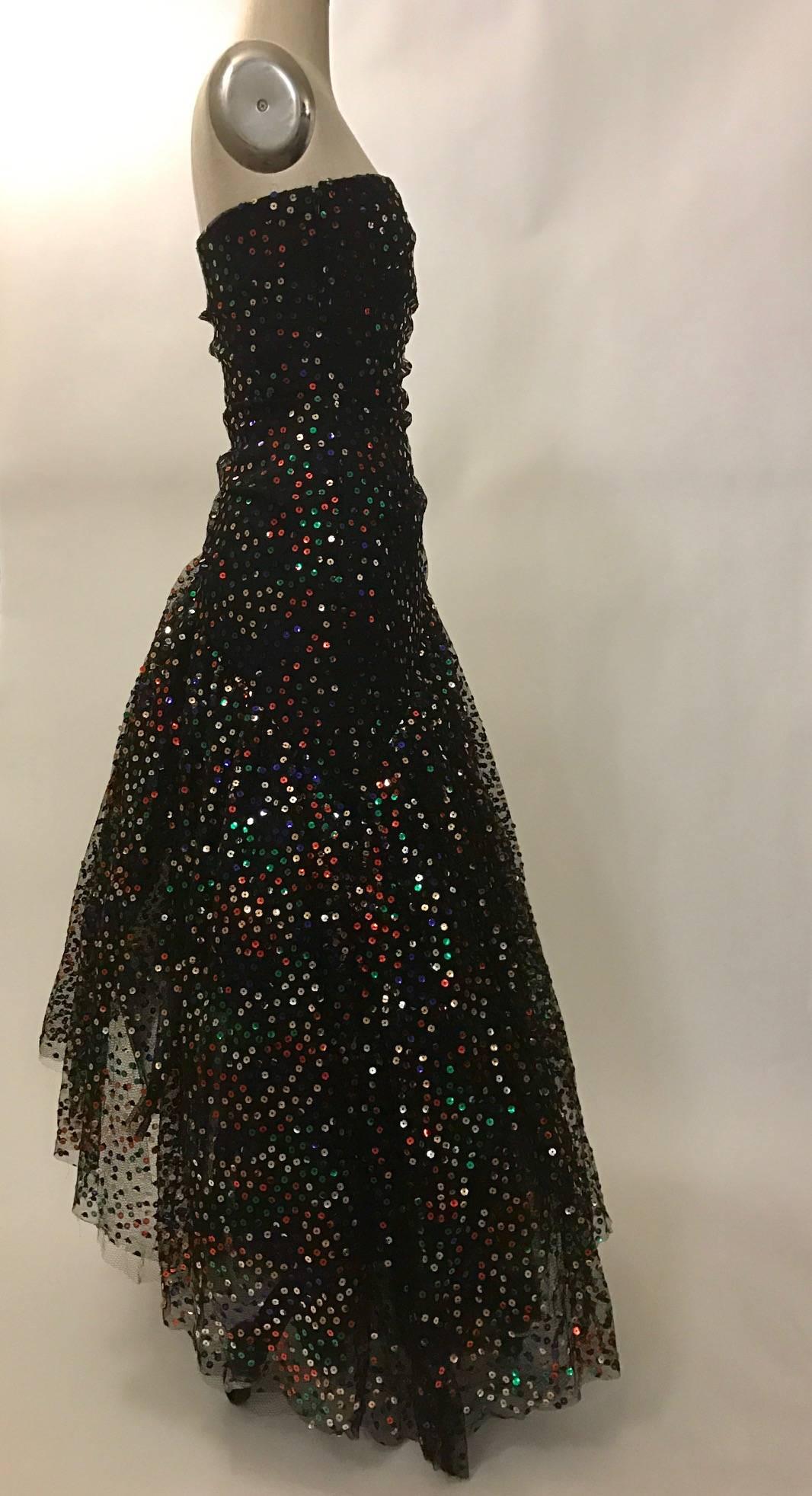 Showstopping  Scaasi Boutique by Arnold Scaasi black strapless sequined gown with voluminous asymmetrical skirt. Slight gathering at waist. Skirt holds it's volume with two layers of stiff mesh tulle, a layer of netting, and the final layer of