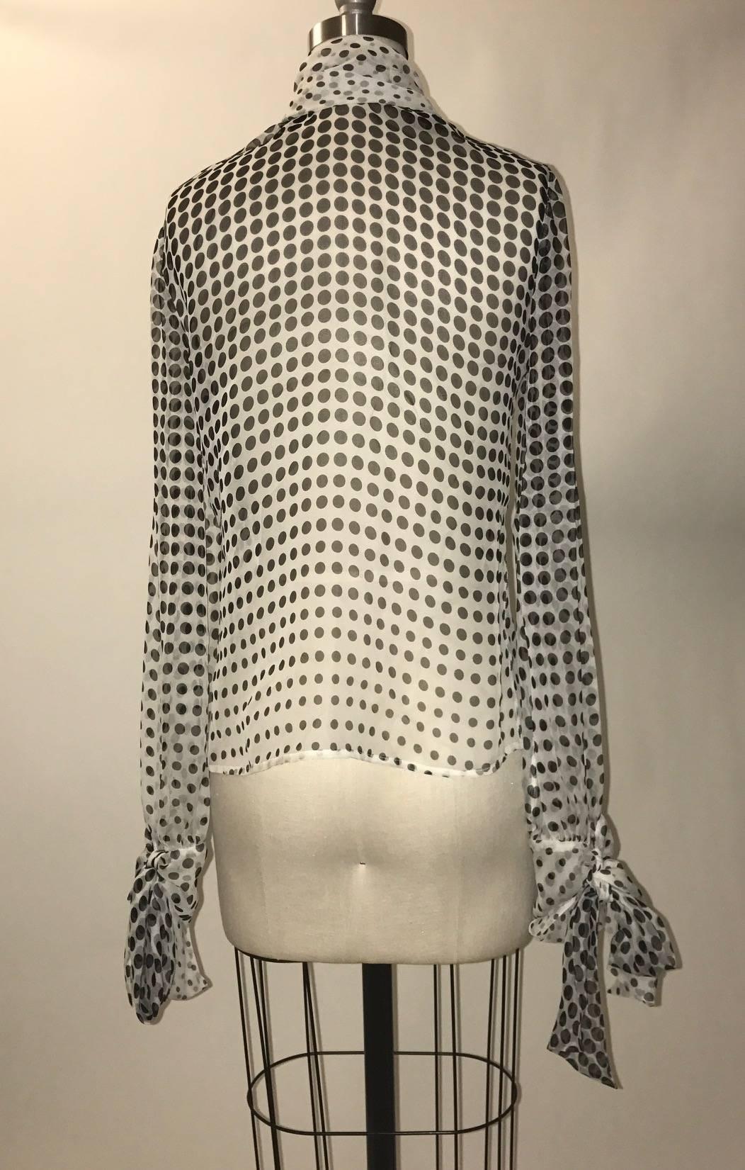 Alexander McQueen 2007 black and white semi-sheer silk polka-dot blouse with tie at neck and matching bows at wrists (can tie into a bow or let hang straight down like a scarf.) Closes at front with concealed buttons.

100% silk.

Made in