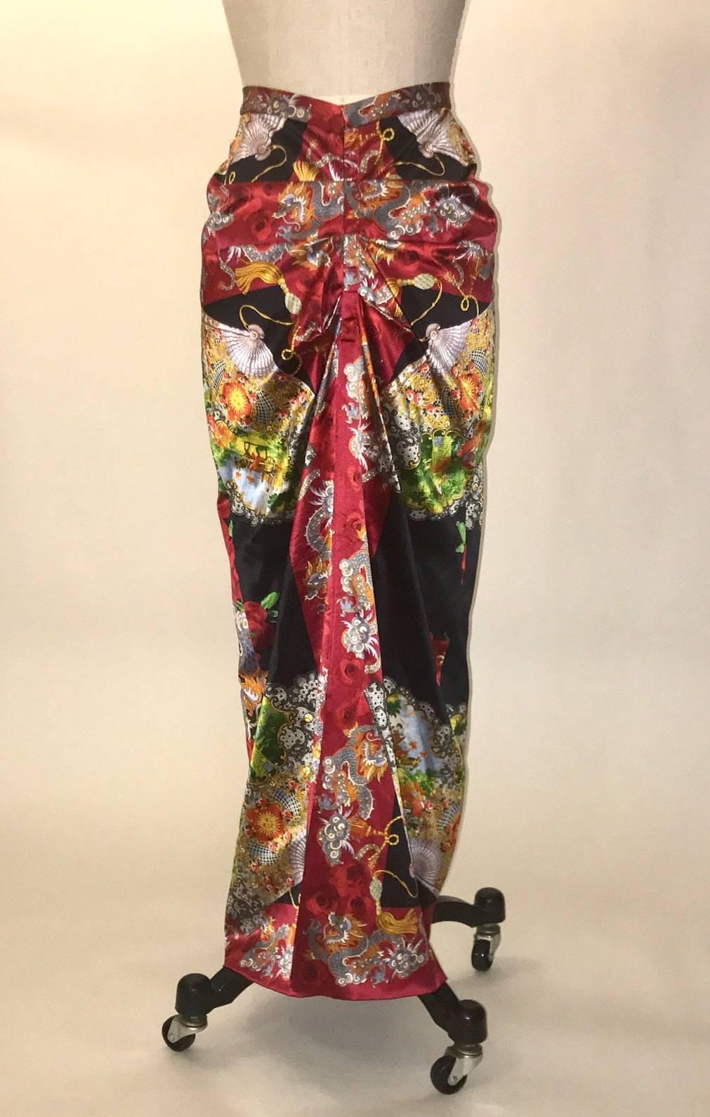 Dolce and Gabbana silk blend skirt features an Asian inspired print featuring dragons, roses and fans depicting countryside scenes. Amazing ruched detailing at back. Closes at back with ten hook and eyes and a snap. Eight inch slit at back center