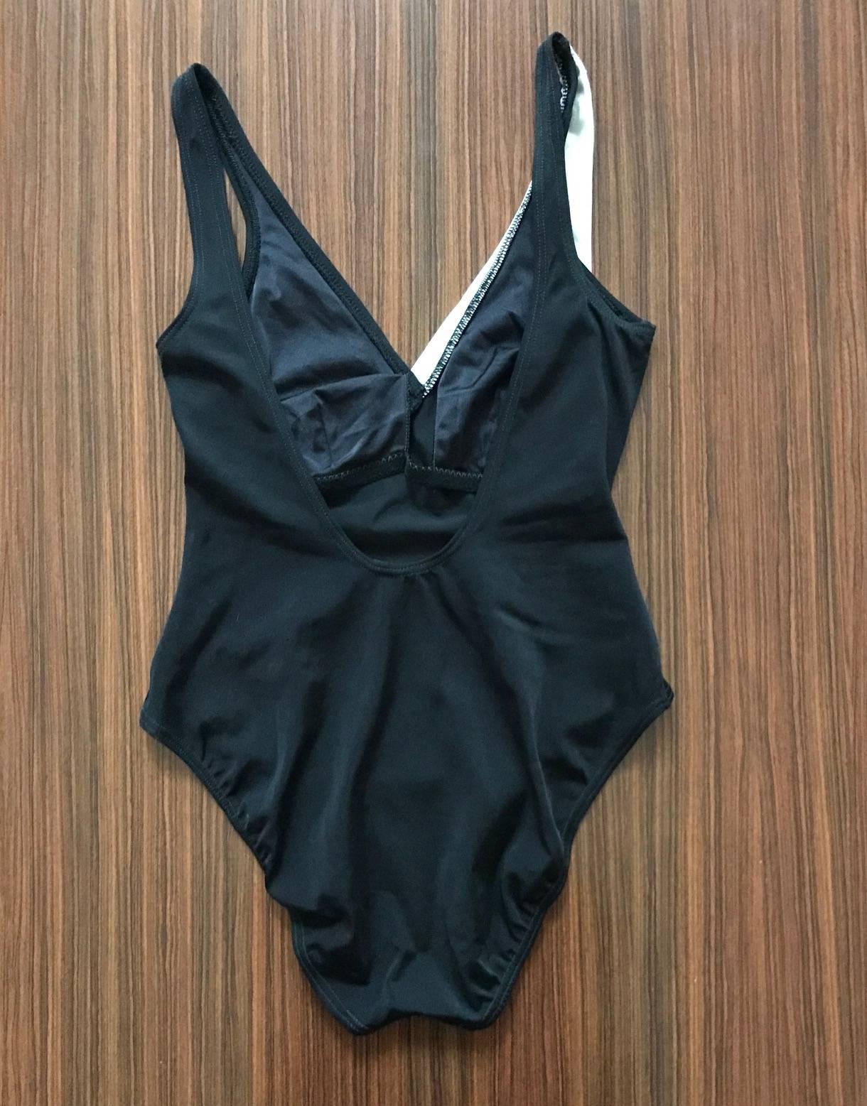 Yves Saint Laurent black one piece swimsuit with asymmetrical white collar detail and four faceted buttons at front. Super flattering high cut legs and scoop back. 

Content/size label removed. 

Best fits size S, see measurements. Stretchy,