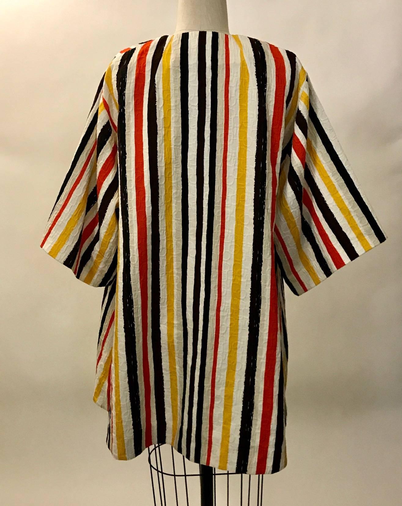 Dolce and Gabbana Spring 2013 wide sleeve robe inspired swing coat in white, putty, yellow, orange, black, and brown painterly stripes. Textured weave. Patch pockets at front. Open front with single hook and eye closure at top.

Shown on the Spring