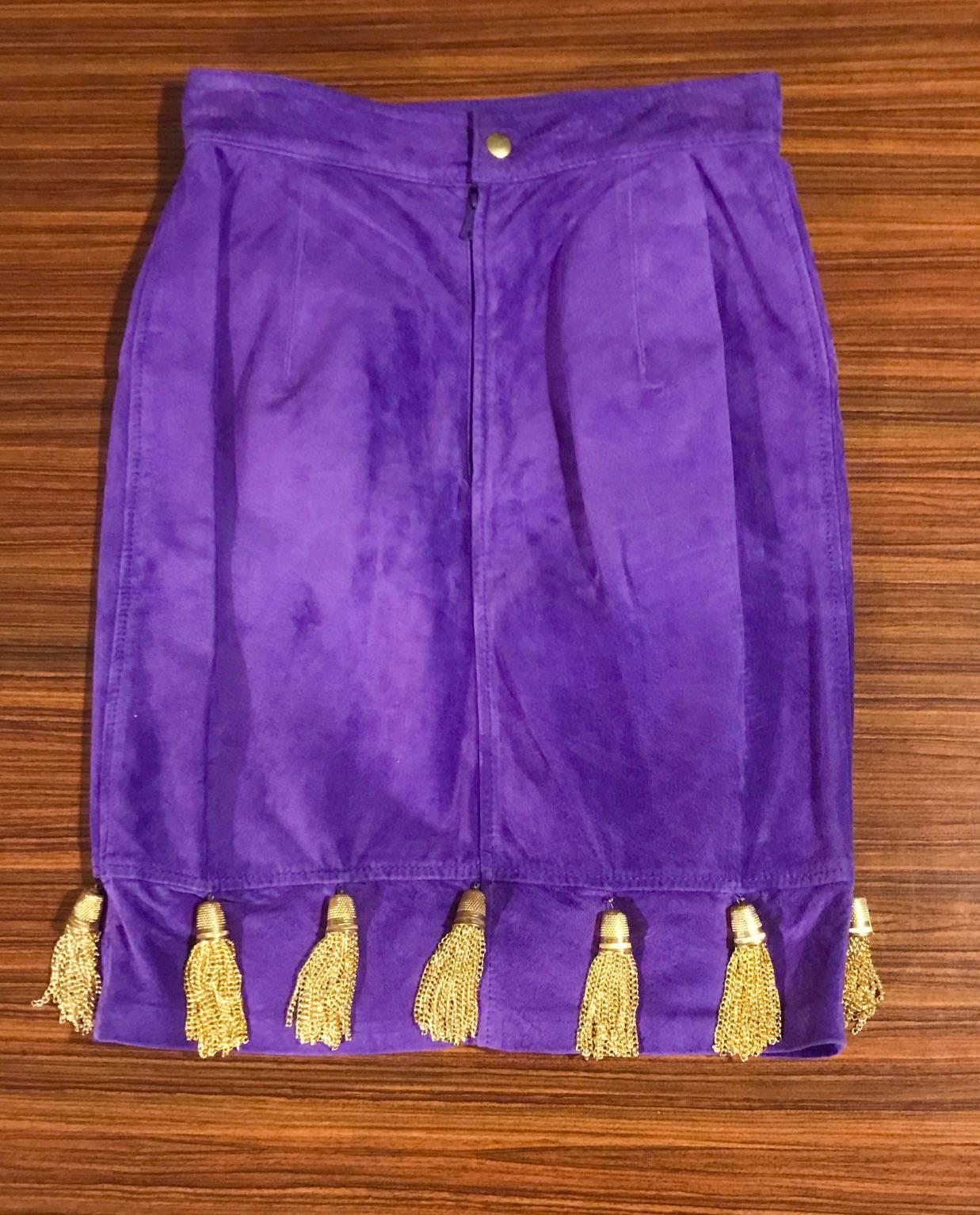 Moschino vintage 1980's 'Pret a Porter' purple suede pencil skirt. Gold thimbles with chain tassels dance around the hem and hang from two front zippered pockets. Back zip and snap.

100% leather.
Fully lined in 100% viscose.

Made in Italy.