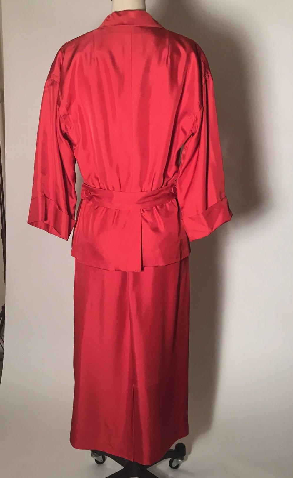 Christian Dior red silk twill suit from the Christian Dior Original line, Dior's first pret-a-porter line, which began in the late 1940s. Dropped shoulder, over-the-elbow cuffed sleeves. Cloth covered button accents with a single breast pocket and