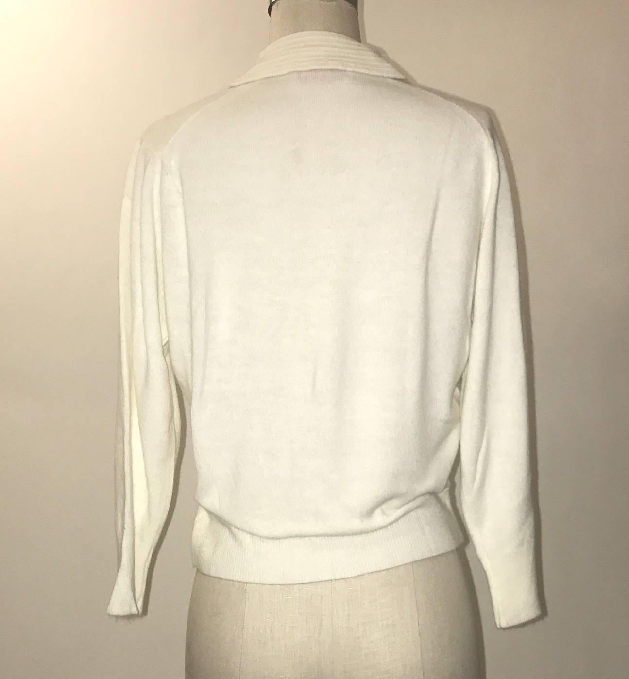 Schiaparelli 1960s super soft white cardigan sweater with rib knit collar detail, beaded floral design at side, and rhinestone buttons.

Signed 'styled by Schiaparelli Paris at label.'

No content label, feels like an extra soft blend of wool/angora