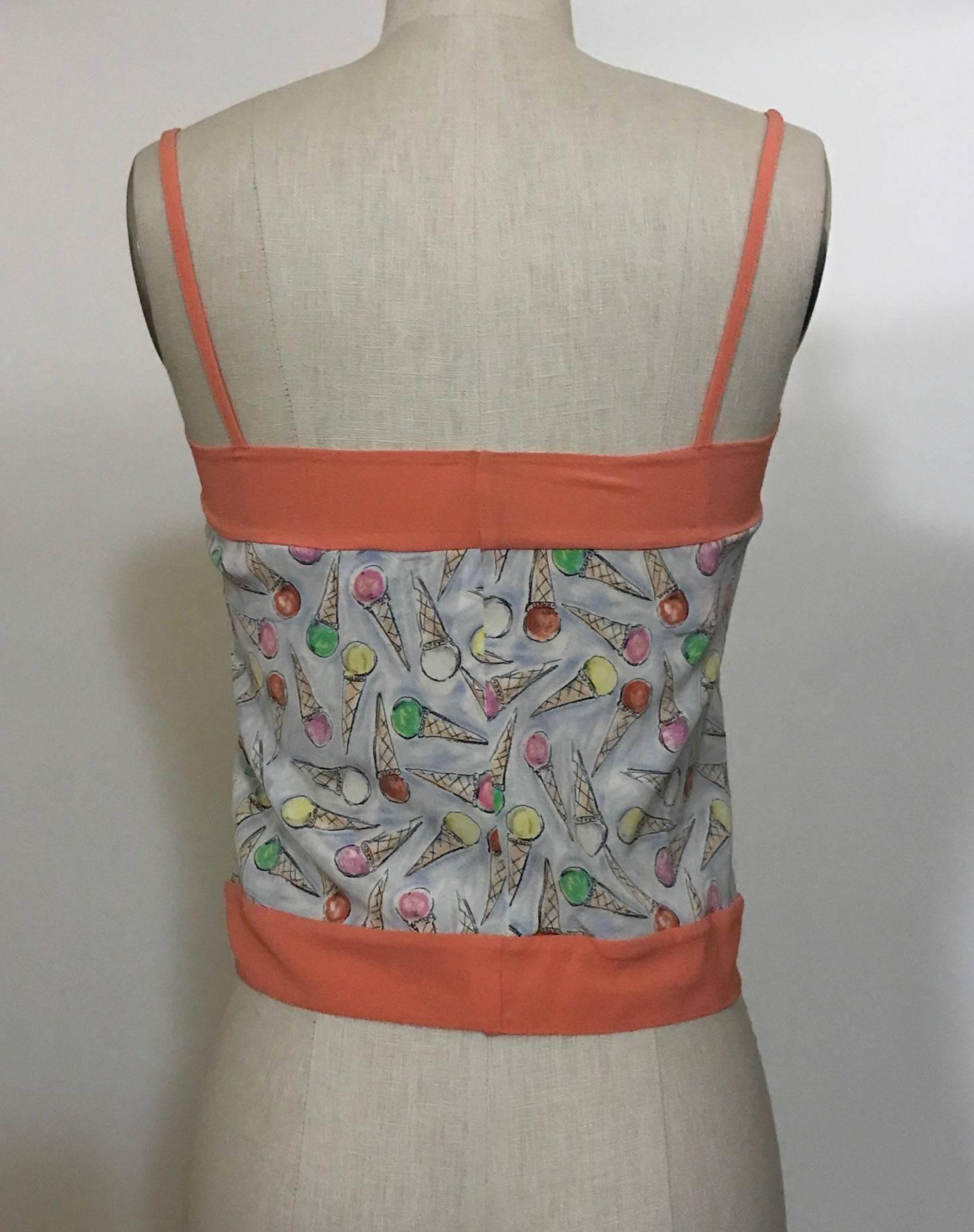 Chanel pale blue-grey slightly cropped top with multi-color ice cream cone print and salmon pink trim from Karl Lagerfeld's 2004 Chanel Cruise collection. 

93% silk, 7% spandex.
Trim 92% silk, 8% spandex.

Made in Italy.

Labelled size FR 36, US 4,