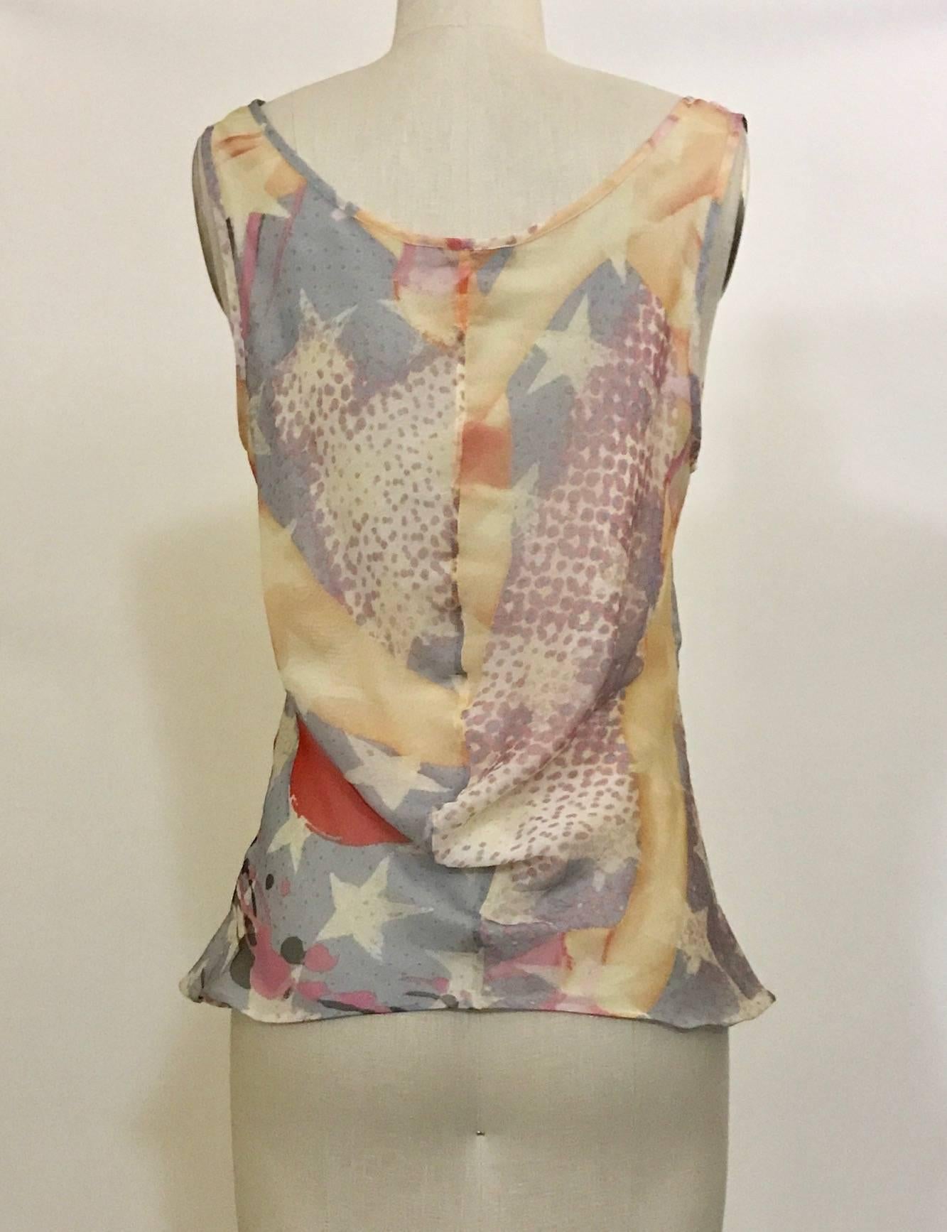 Alexander McQueen 2003 multicolor sleeveless silk chiffon top with abstract print throughout featuring stars and a pin up girl. Solid ivory underlay.

Content label removed, feels like silk chiffon.

Made in Italy.

No size tag, estimated size M.