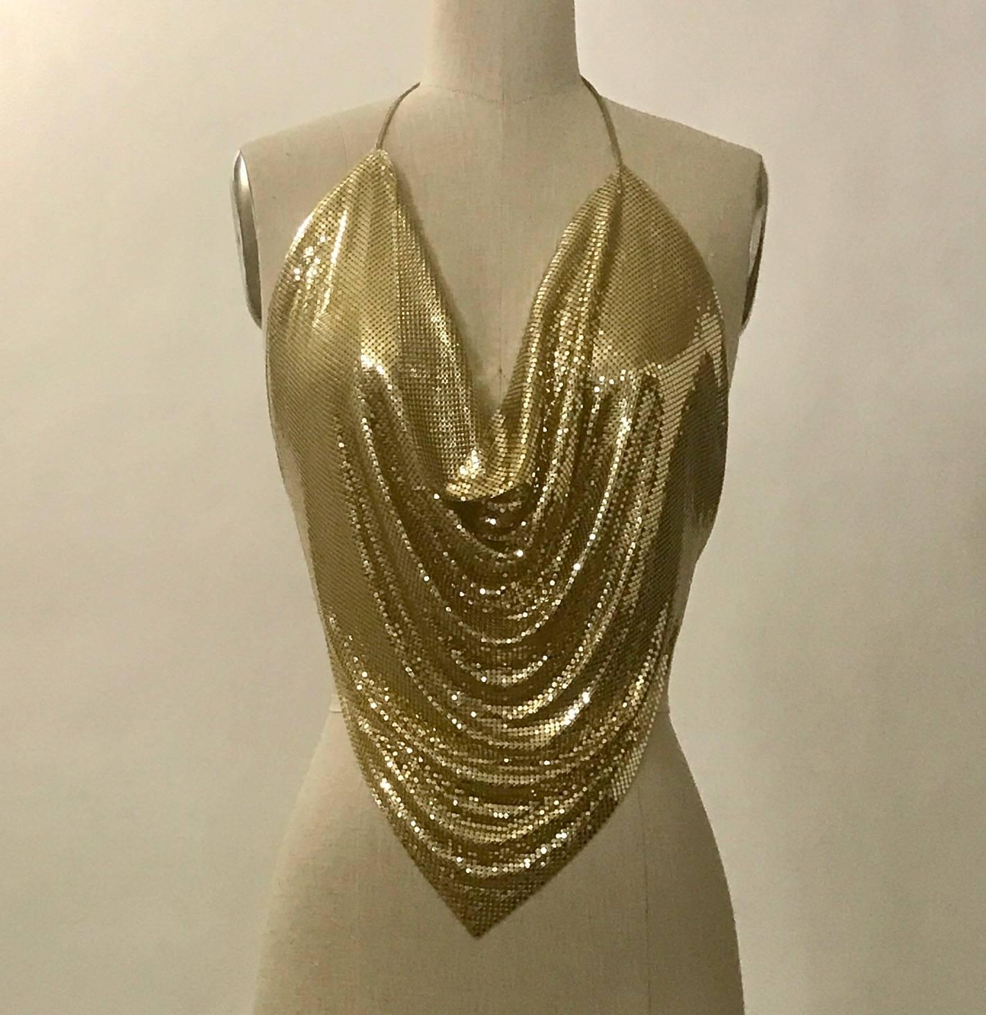Vintage 1970s gold metal mesh halter top with gold leather string ties at neck and back. 

No label, possibly Stephen Burrows or Whiting and Davis.

One size. Shown on a size 2 dress form. 

Very good condition, would be excellent except for some of