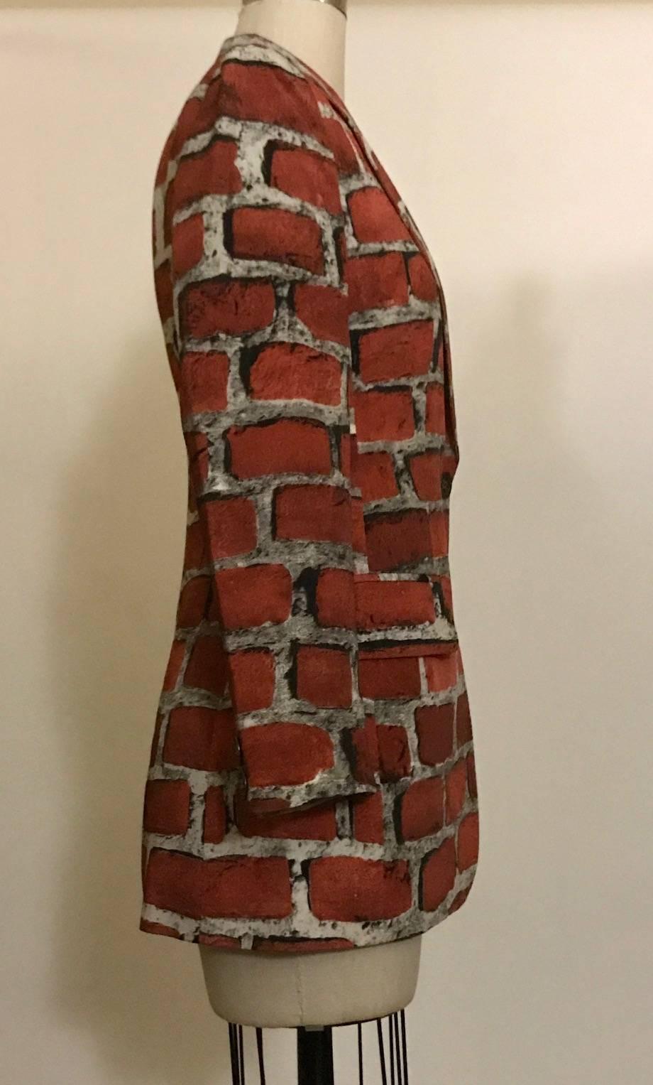 Moschino Couture brick print jacket from the 1997 collection. Orange red bricks on a grey cement background. Buttons at front and cuffs.

90% acetate, 10% silk.
Fully lined in 60% acetate, 40% rayon.

Made in Italy.

Labelled size IT 40, US 6. Best