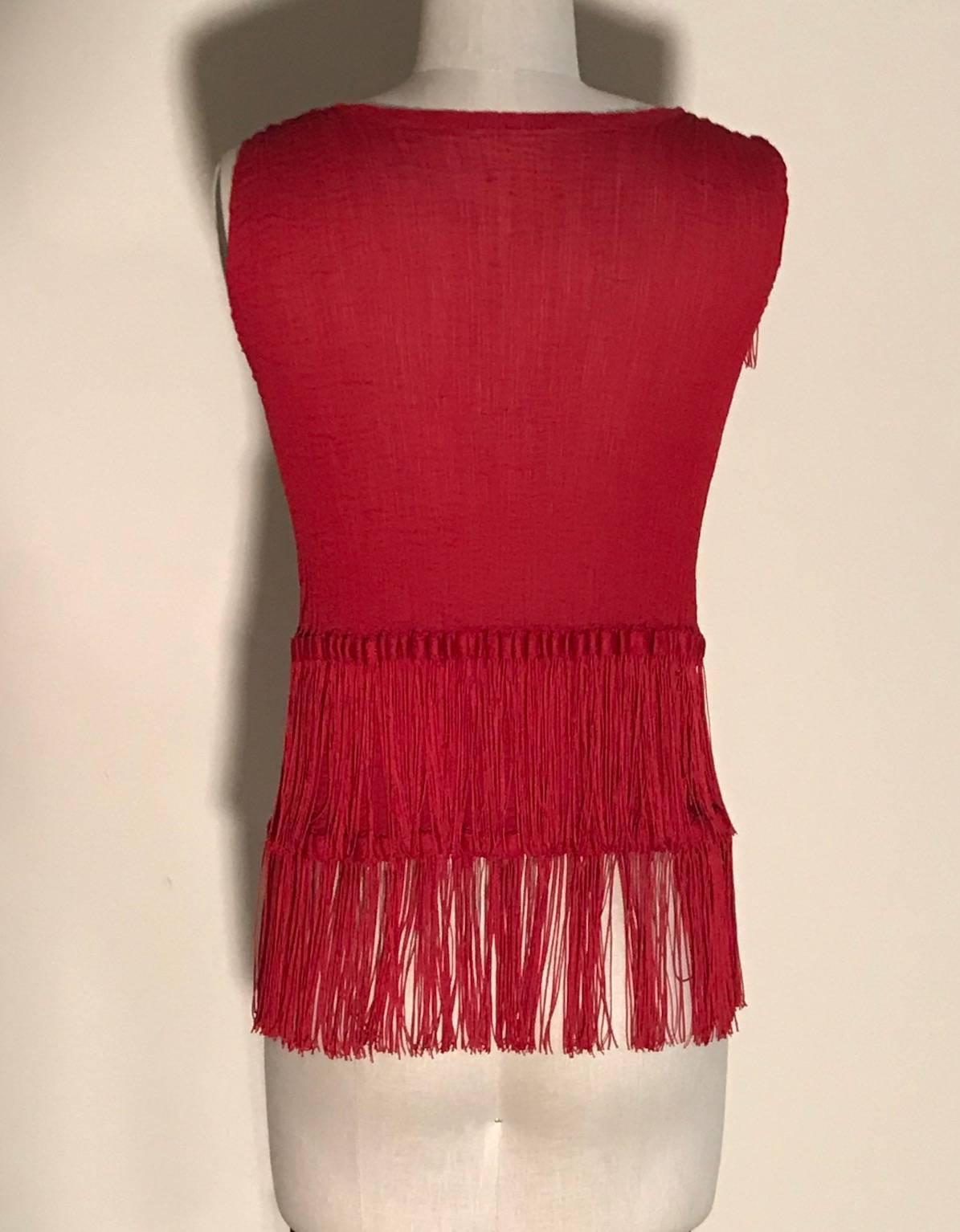 Issey Miyake red fringe tank top from the Me Issey Miyake label. Sleeveless with crinkle pleats throughout and tassel trim at shoulders and hem.

No size, best fits XS/S. See measurements. (Tonss of stretch, measurements taken unstretched. Pictured