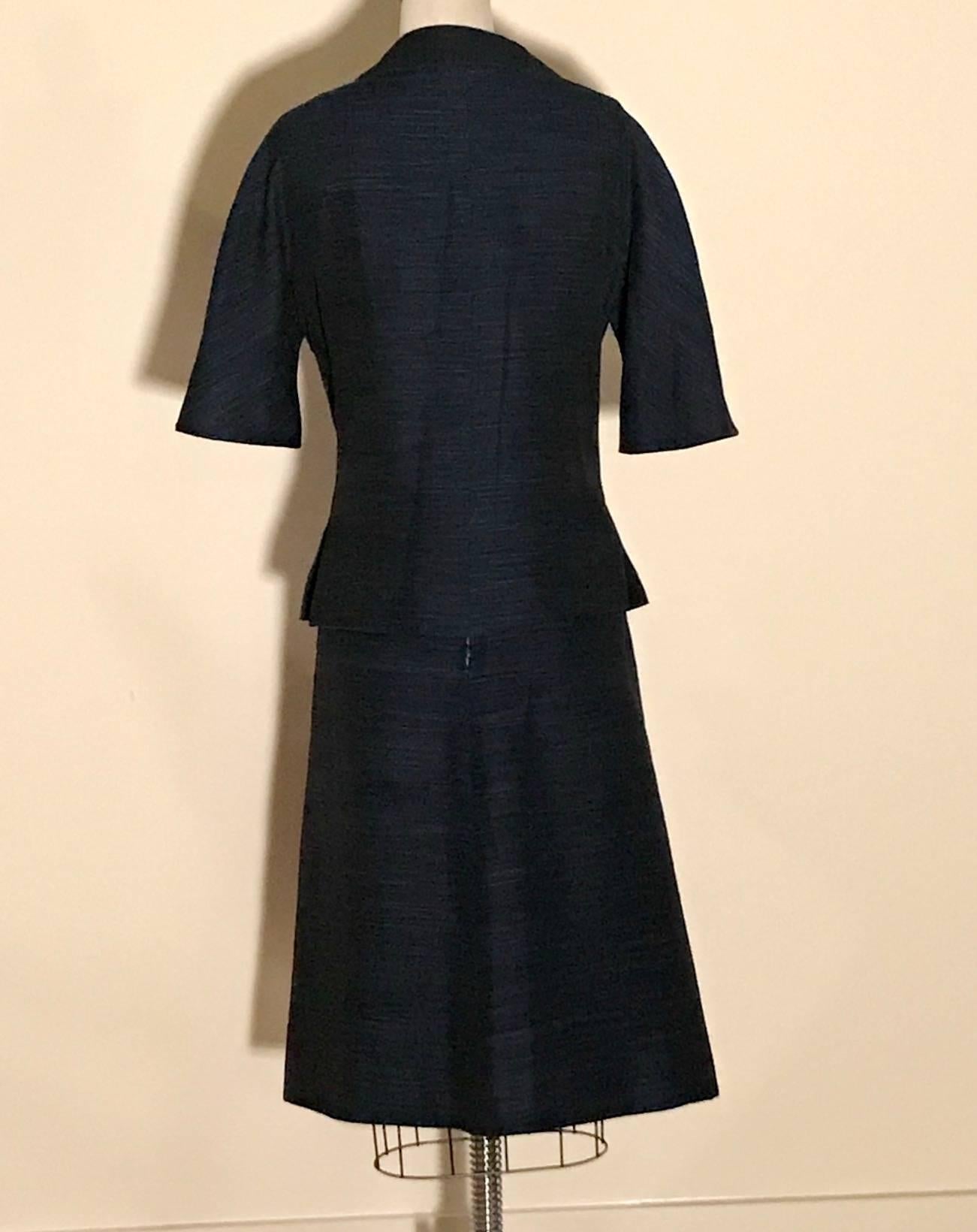 Vintage Christian Dior blue and black skirt suit featuring jacket with elbow length sleeve, front pockets, and novelty buttons along with matching A-line skirt. Most likely early 1960's. Jacket fastens with four buttons and a concealed snap at