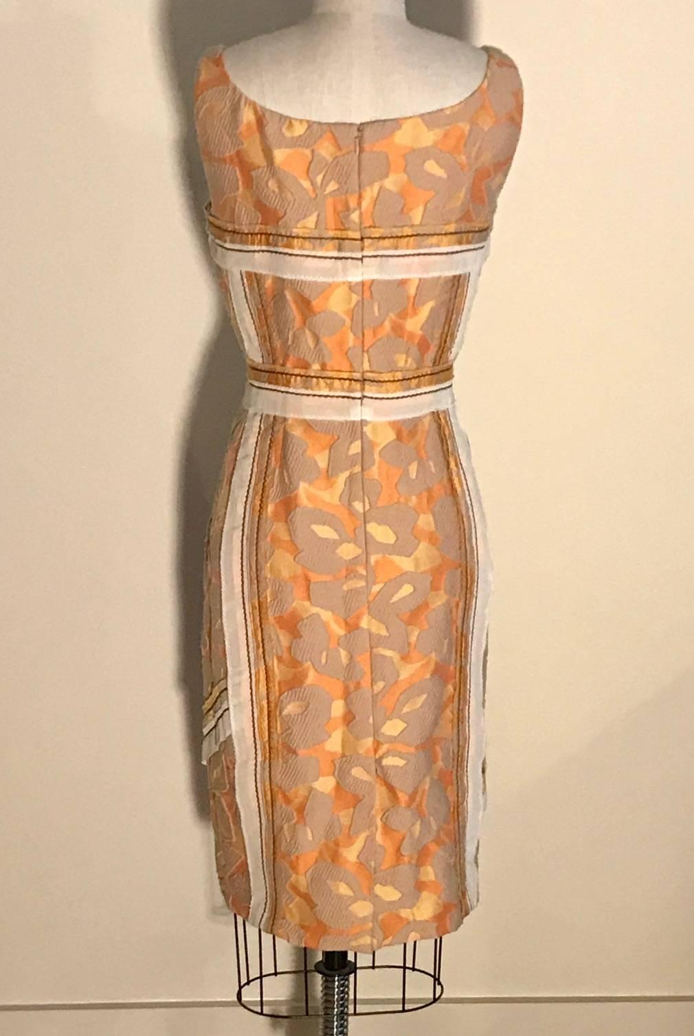 Ärmelloses, gerade geschnittenes Kleid von Prada mit abstraktem, goldorangem und gelbem Muster und kontrastierenden Zierleisten. Rückenreißverschluss und Haken und Ösen.

Wie in Look 22 der Prada-Frühjahrsshow 2015 zu sehen. 

49% Nylon, 43%