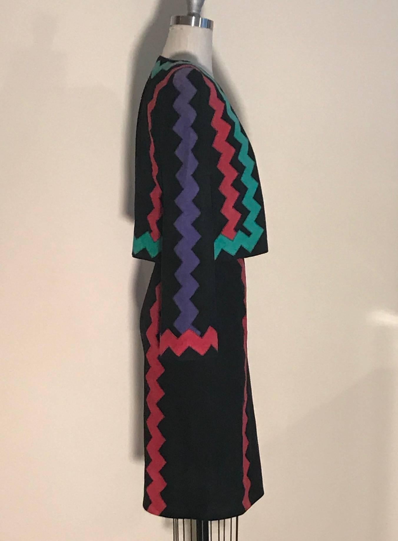 Yves Saint Laurent Rive Gauche vintage 90s black suede skirt suit, featuring red zig zags at pencil skirt, and red and green zig zags at jacket, with a purple zig zag down the sleeves. Jacket is open front with pockets at side front. Skirt has side