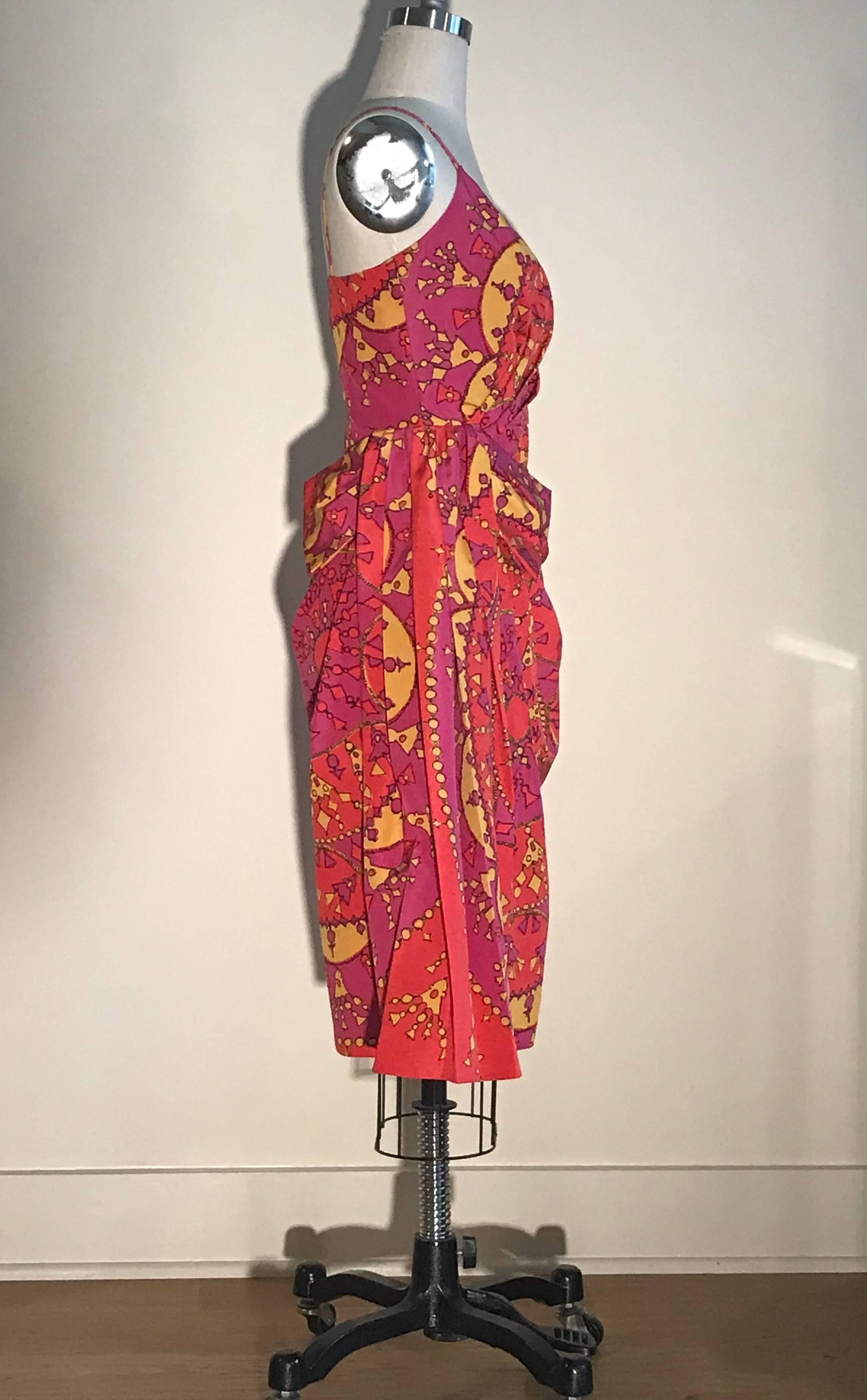 Christian Dior pink and yellow tassel pendant print dress. Draped detail creates volume at waist and a bow like flourish at side. Side zip and hook and eye.

51% cotton, 49% silk.
Fully lined in 100% silk.

Made in France.

Labelled size FR 38, US 6