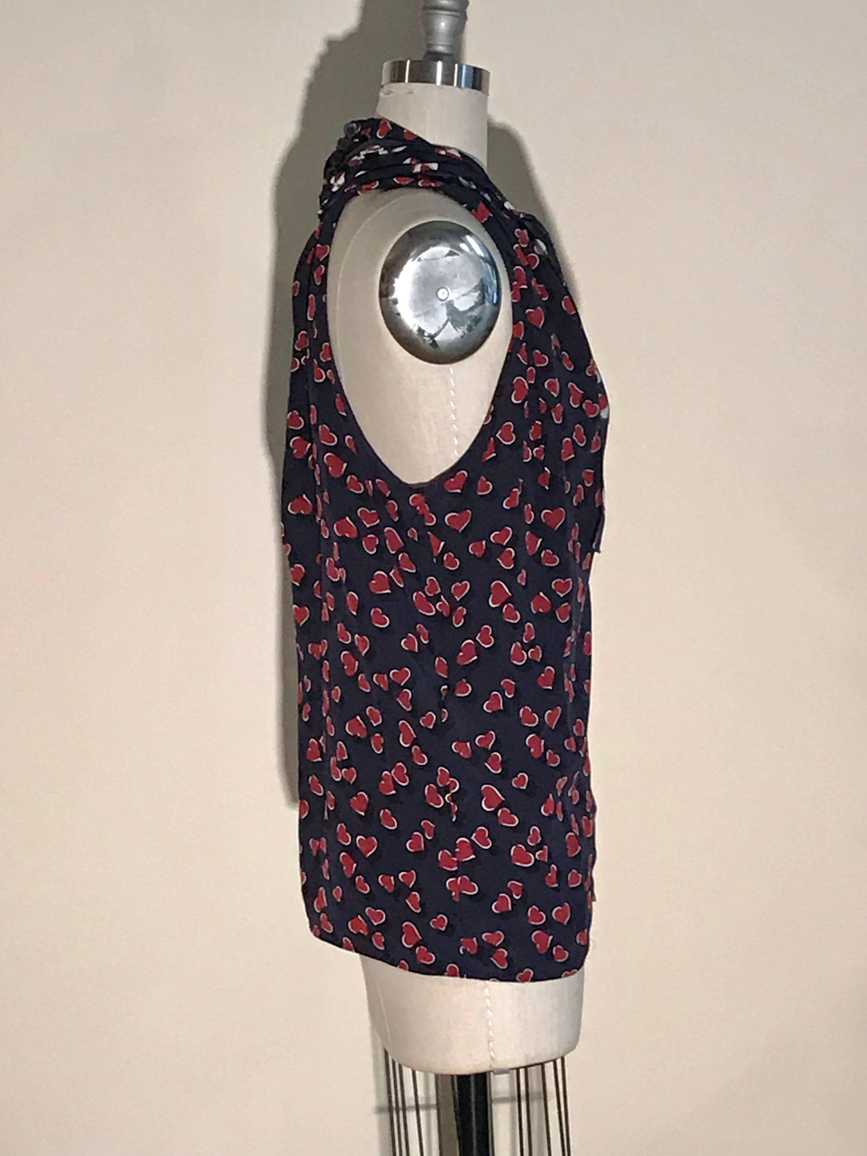 Gucci blue and red heart print silk top with beach ball print accent at neck. Deep V neck at front and slit at back with buttons at back neck. Scarf detail can be left open or tied however you'd like to style it. 

100% silk.

Made int Italy.

Size