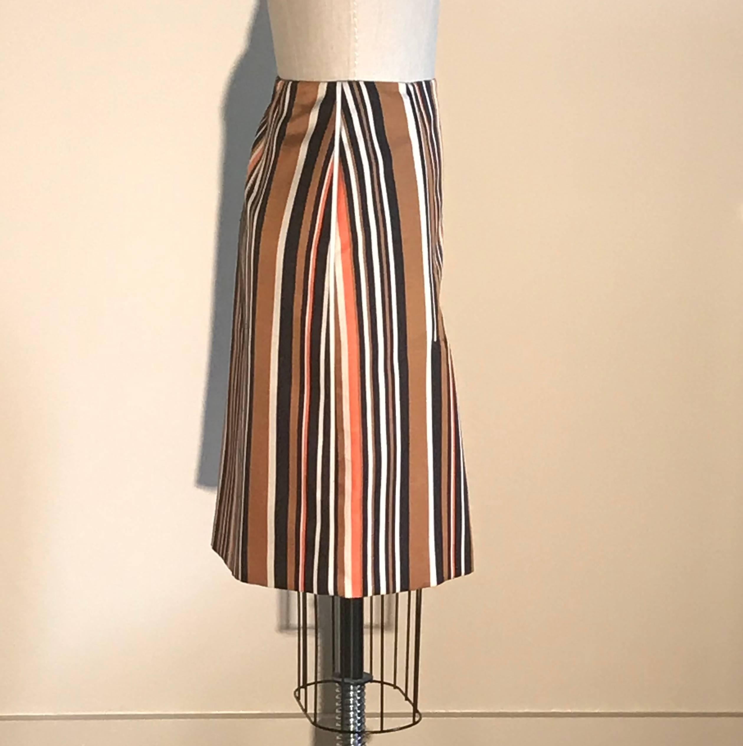 Prada orange, brown, and white striped pencil skirt with white piping detail at front darts and side seams. Side zip.

57% wool, 43% silk.
Fully lined in 66% viscose, 34% silk with polyester interfacing.

Made in Italy.

Size IT 38, approximate US
