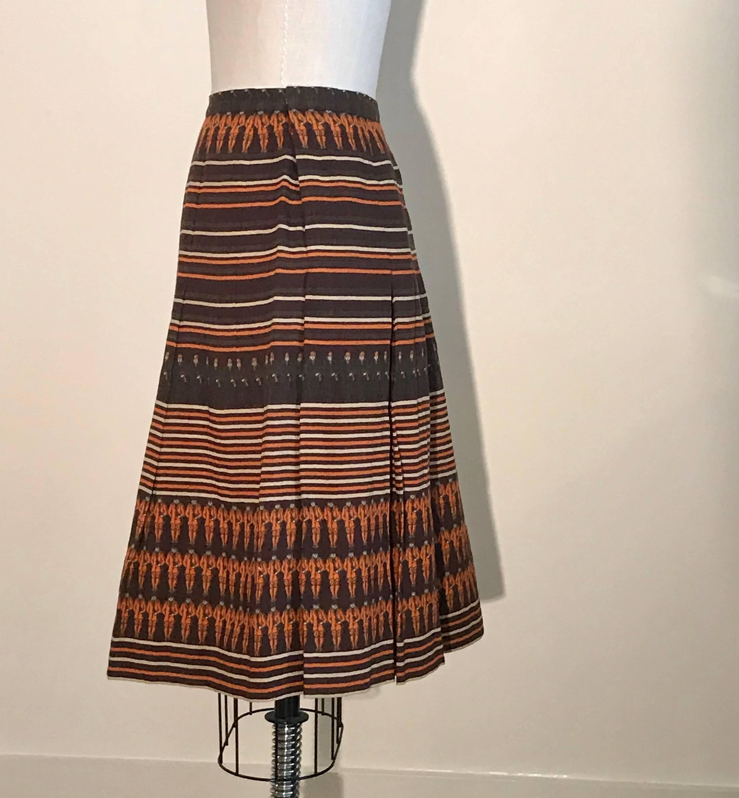 Amazing Gucci vintage 1970s wool blend pleated skirt featuring stripes and orange and green equestrian jockey print. Fastens with snaps at side and two hook and eyes. Gucci logo print lining. 

85% wool, 15% polyamide. 

Made in Italy.

Size IT 46,