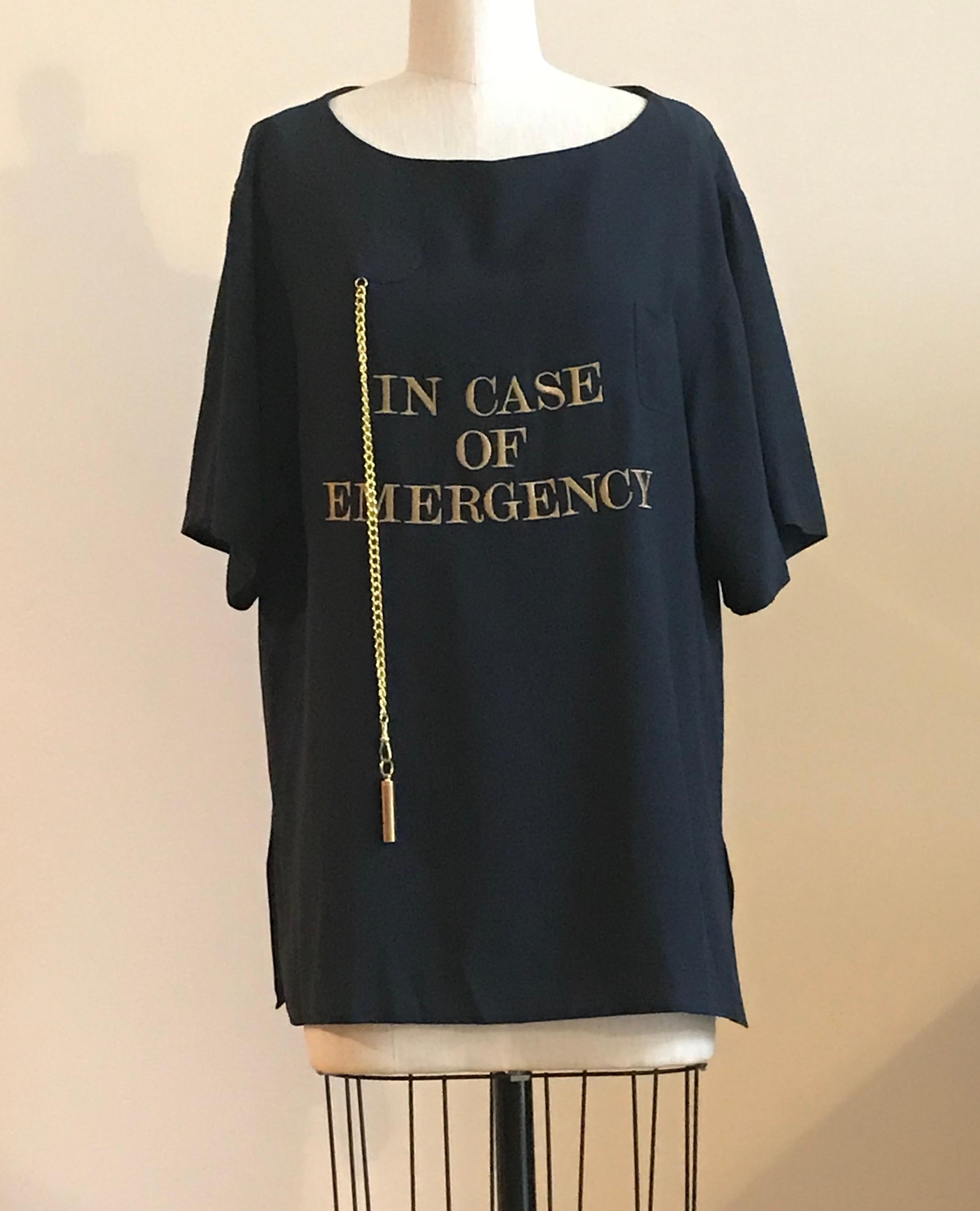 Moschino Couture late 1980s or early 1990s vintage navy blue oversized t-shirt cut top featuring In Case of Emergency in gold embroidery. A gold whistle (it works!)  dangles from a chain on one side, and can be tucked into a tiny pocket at the
