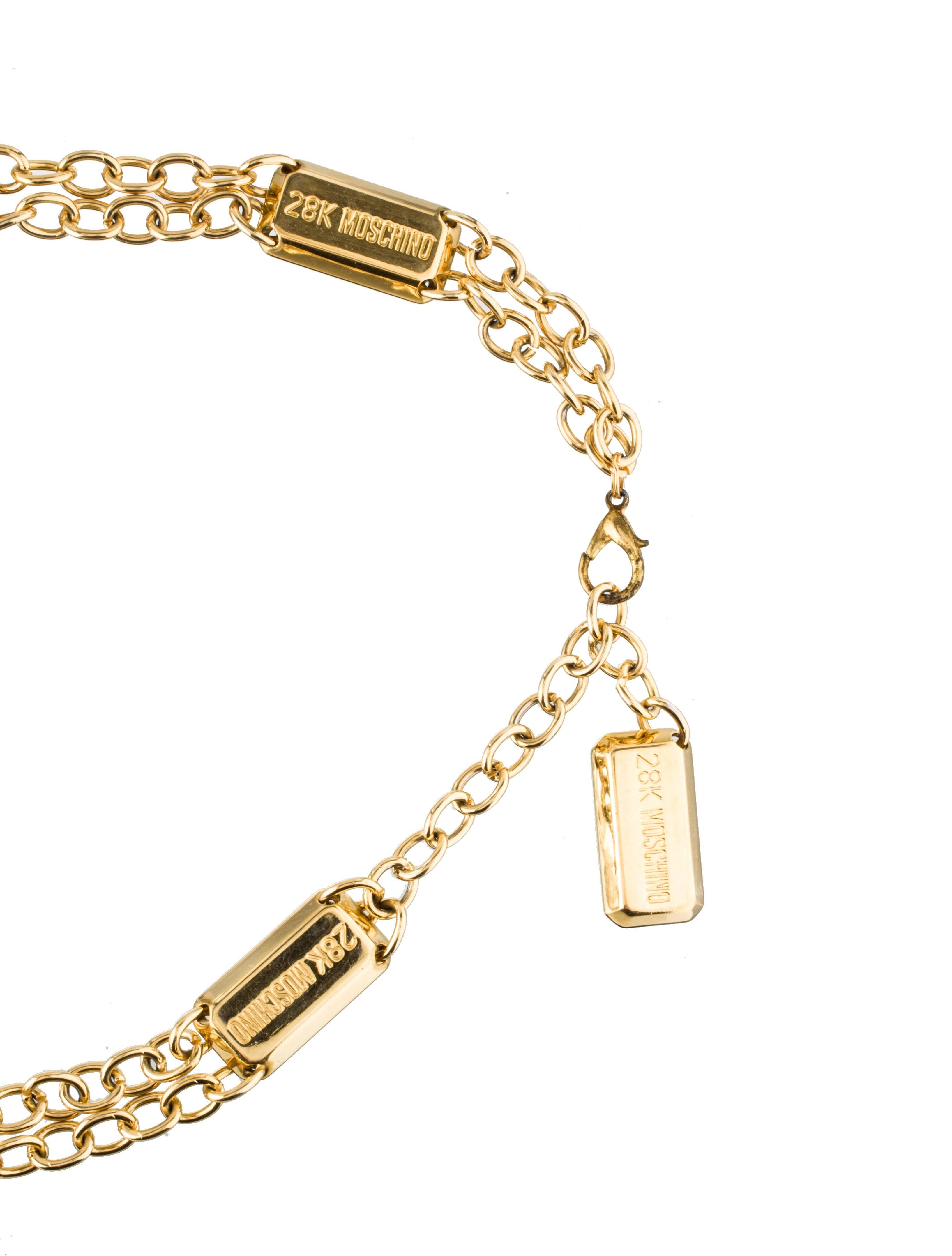 Moschino vintage 1990's Redwall chain charm belt featuring mini gold tone bars that read '28k Moschino.' Each bar is stamped 'Redwall, made in Italy' at back. 

Measures approximately 35