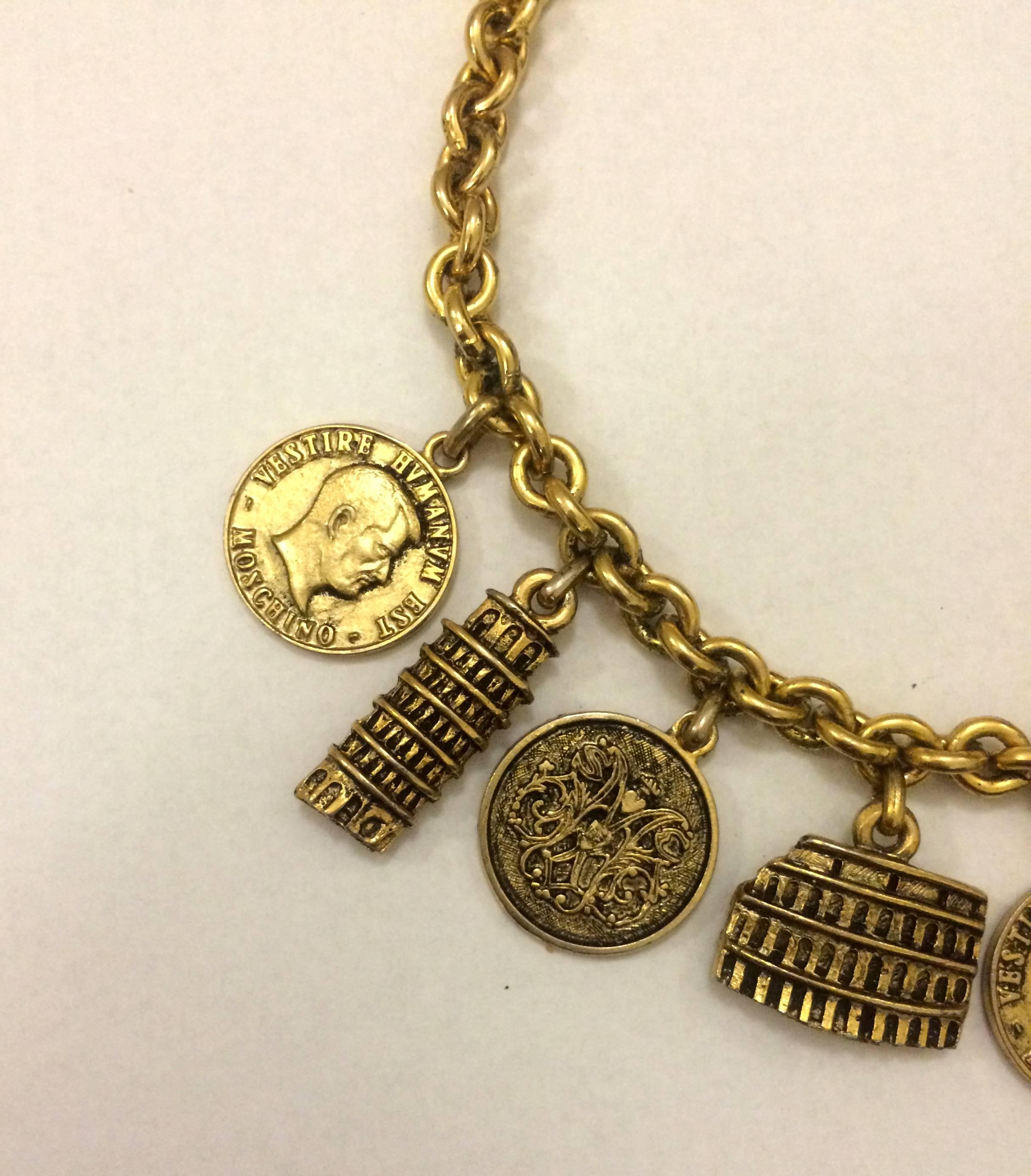 Vintage late 80s Moschino Bijoux Italian charm necklace. Depicts the Coliseum, tower of Pisa, and more Italian icons mingled between coins featuring Moschino insignia.

17