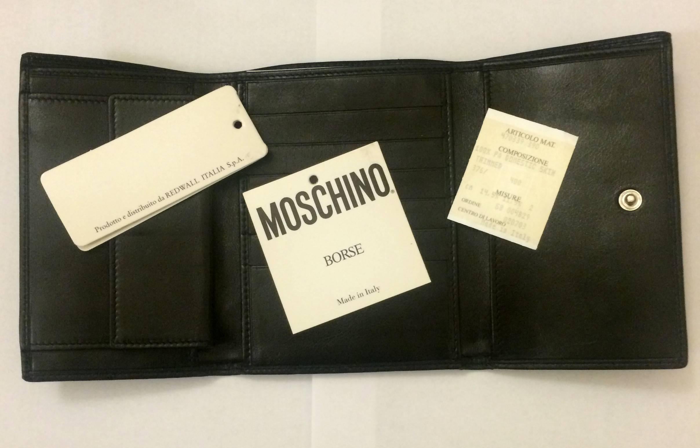Vintage 90's Moschino by Redwall tri-fold wallet (or mini clutch-- it's so cute you might not want to keep it in your bag!)

Nylon exterior features Moschino branded metal detailing with heart and peace sign. 

Measures approximately 4.5