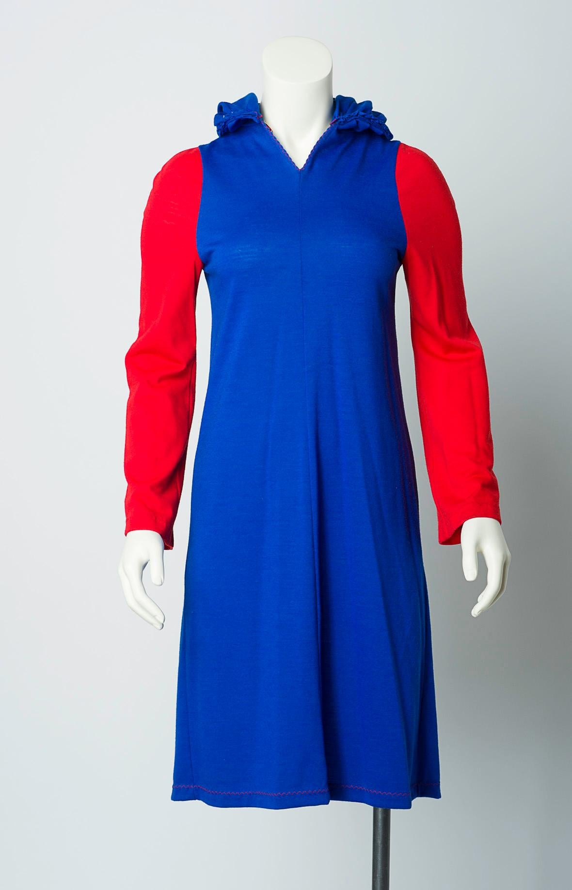 Stephen Burrows red and blue color block dress in lightweight knit. Lettuce edge at hood and red zig zag stitch at hem and seams. Pullover, no closures.

Fabric: Lightweight knit, feels like wool-cotton blend.

Includes Stephen Burrow's World and