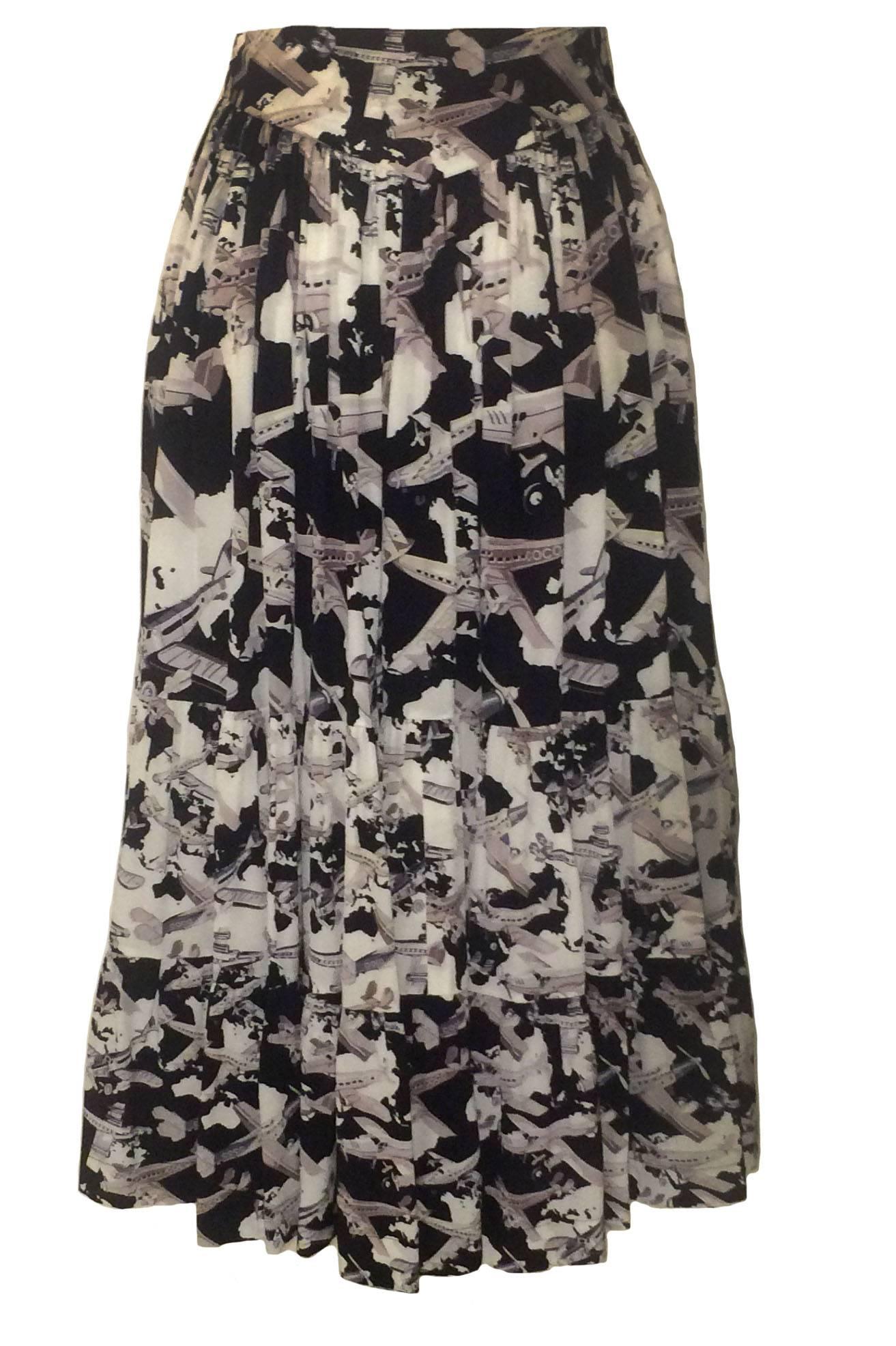 Chanel airplane print skirt from the Spring 2006 collection. Black silk fabric features white clouds and tan and grey planes with 'Coco' 'Chanel Air' and 'CC' logos throughout. Invisible side zip and hook and eye.

100% silk.

Size (based on