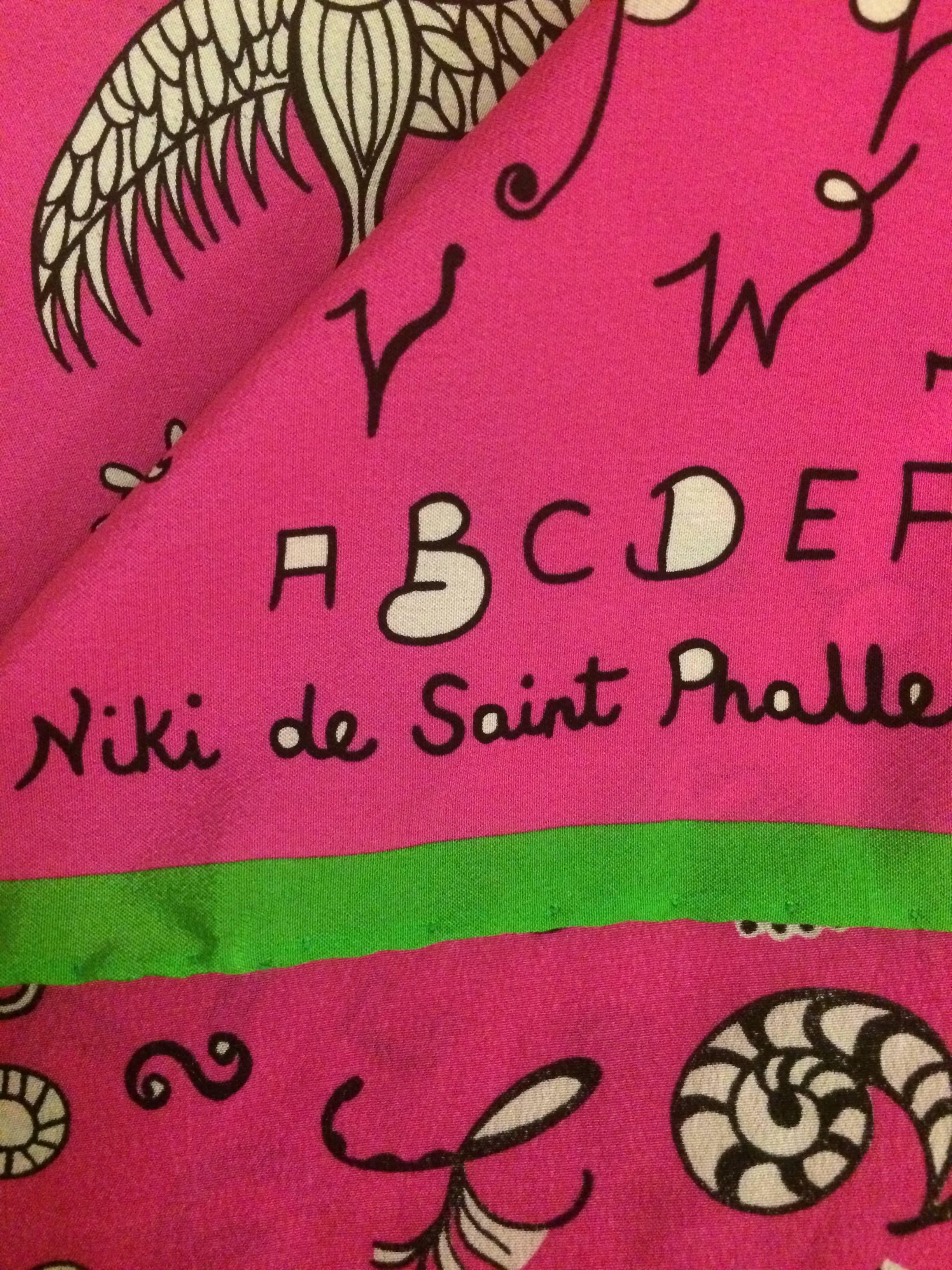 Niki de Saint Phalle hot pink mini-scarf with wacky alphabet print. 

Approximately 14 1/2