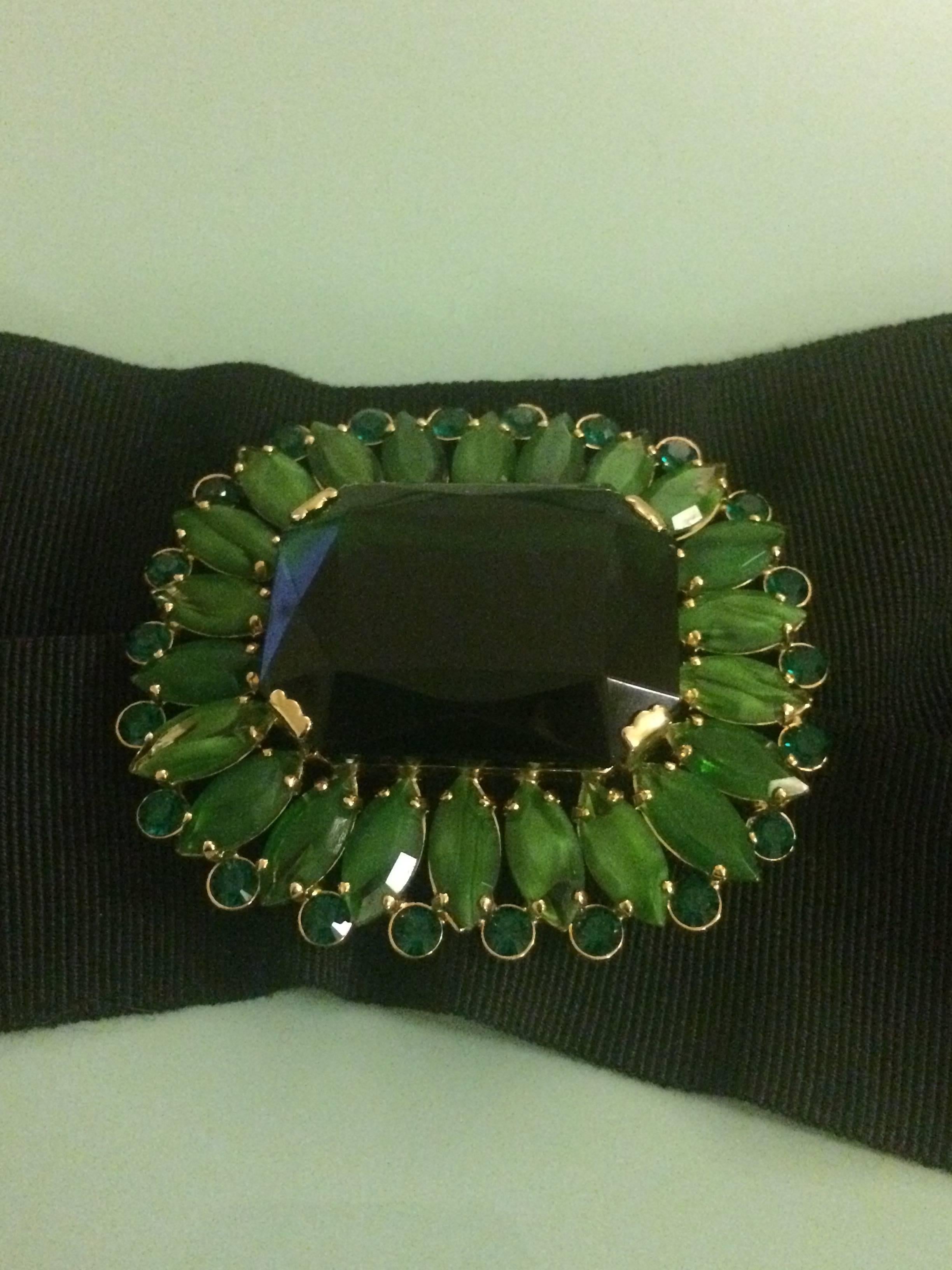 Dolce & Gabbana wide black grosgrain waist belt with green crystal and glass brooch embellishment at front. Closes with three concealed snaps at back. Brooch can be detached (it's held on by a couple stitches) and worn separately with it's own