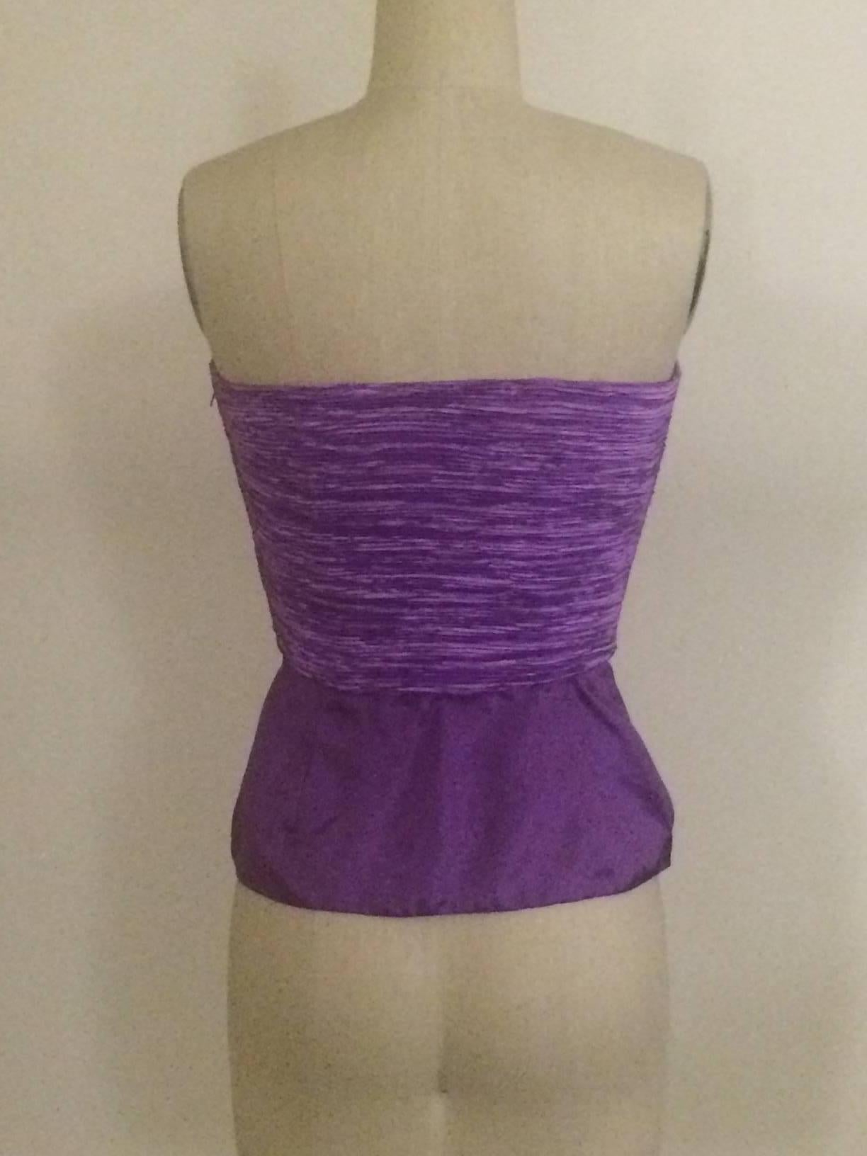 Mary McFadden Couture for Saks Fifth Avenue, début des années 1990, haut à plis signature sans bretelles violet avec bas à péplum. Désossage en haut. Fermeture éclair sur le côté.

100% polyester.

Fabriqué aux États-Unis.

Taille 2, s'ajuste