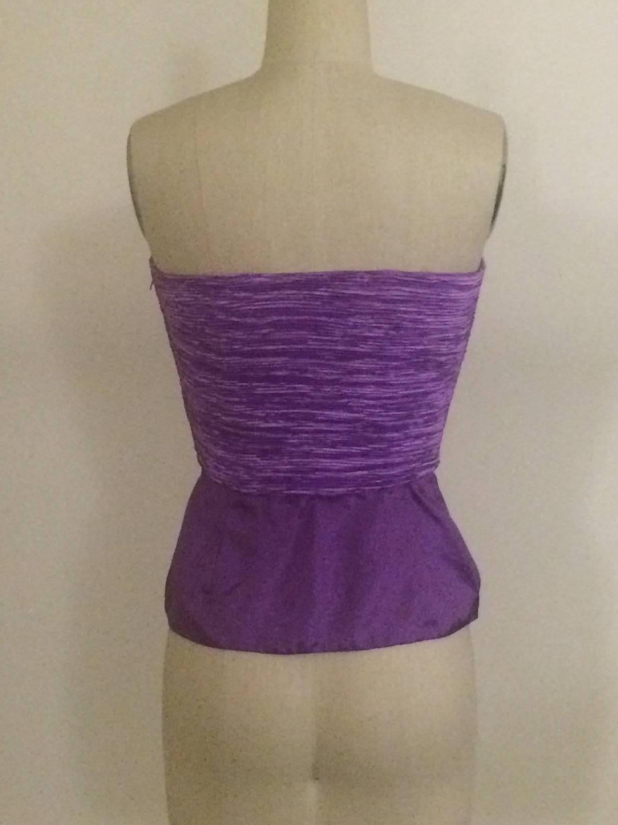 Mary McFadden Couture für Saks Fifth Avenue Anfang der 1990er Jahre lila trägerloses Oberteil mit Schößchen unten. Ausschnitt oben. Seitlicher Reißverschluss.

100% Polyester.

Hergestellt in den USA.

Größe 2, passt wie eine moderne 0. Siehe