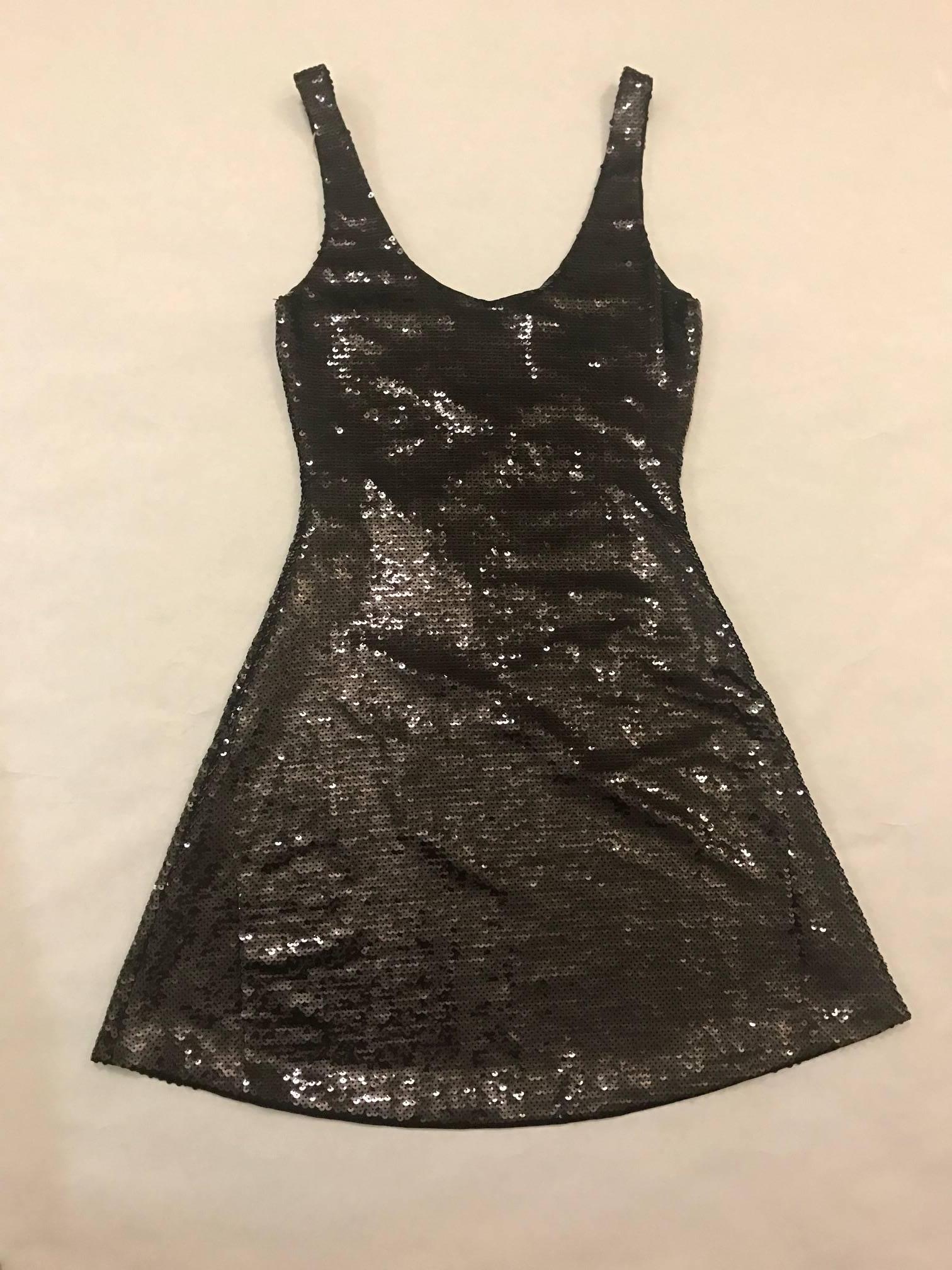 Recent Moschino Couture! by Jeremy Scott skater cut black sequined dress reads 'Little Black Dress' in white sequins at front. Sleeveless, scoop neck. No zip, pulls on.

100% polyester.
Fully lined in 98% nylon, 2% spandex.

Made in Italy.

Labeled