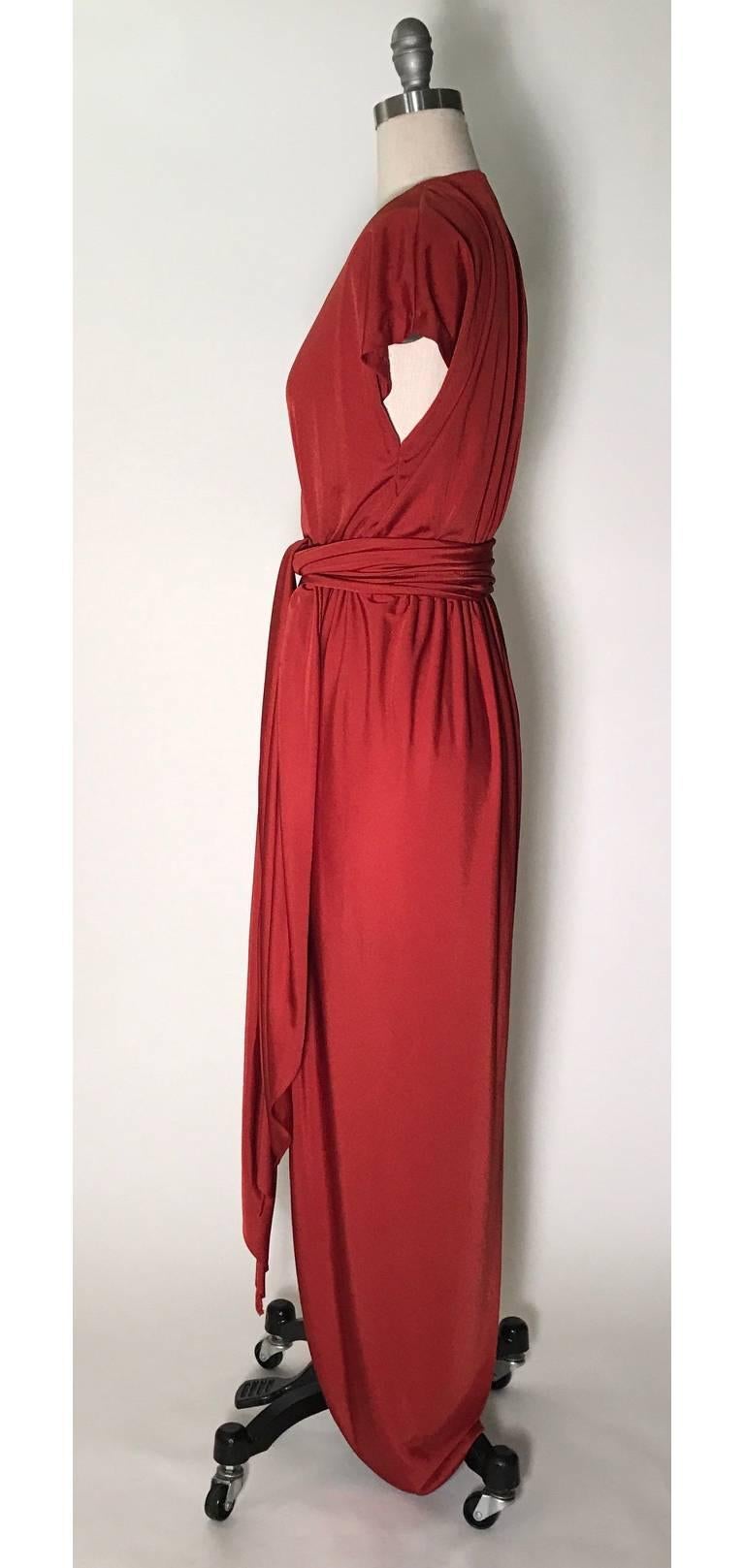 Halston IV vintage jersey wrap dress in rust red from Halston's 1980's licensed collection for Dorian. V-neck and short sleeves. Elastic waist fastens with two hook and eye closures. Removable long wide belt presents many styling possibilities!