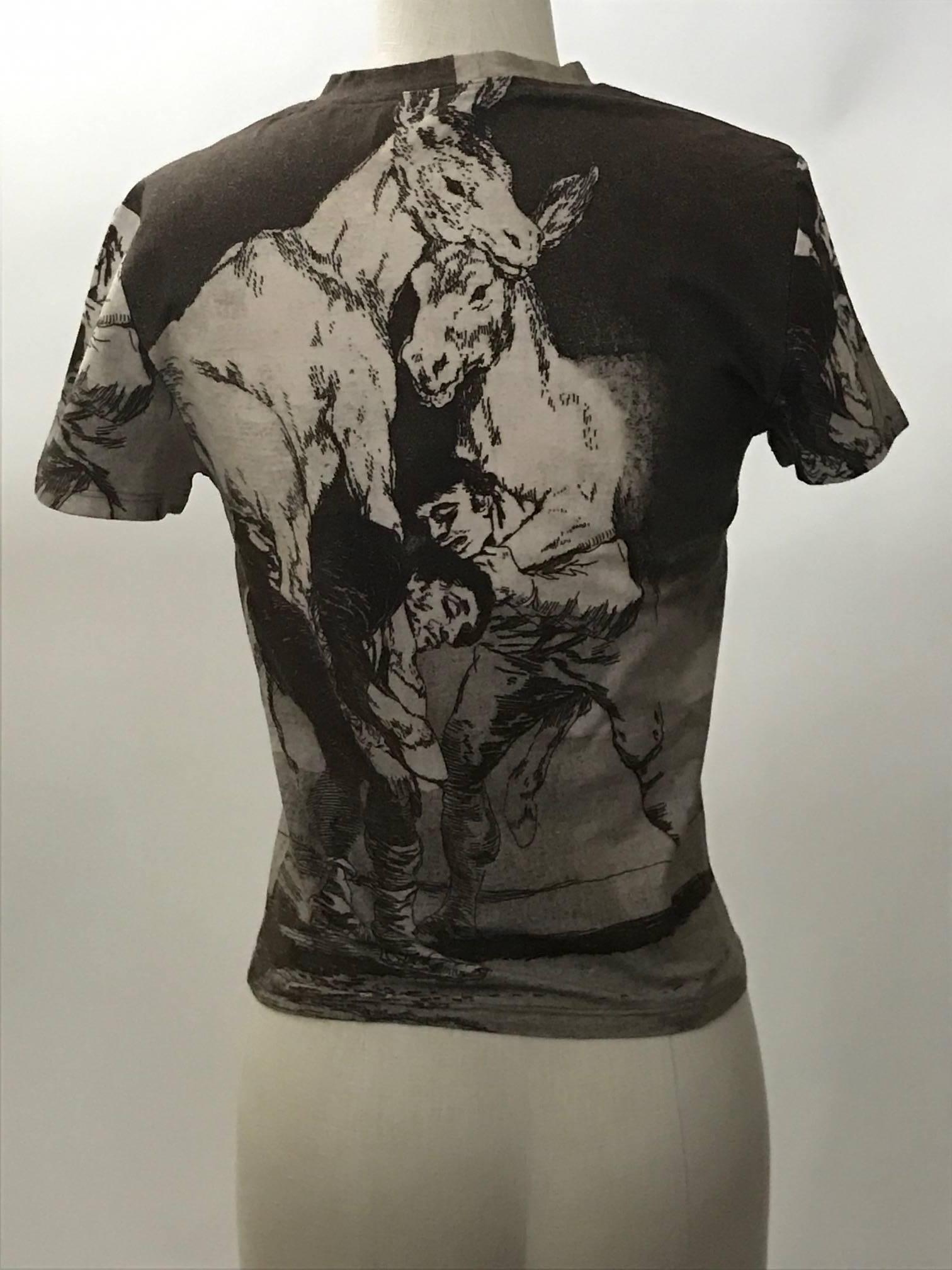 Extremely rare Alexander McQueen 1990s short sleeve crew neck t-shirt in light chocolate brown featuring Francisco Goya's 1799 print Tu Que no Puedes (They Who Cannot) from the series Los Caprichos featuring two men straining to carry a pair of