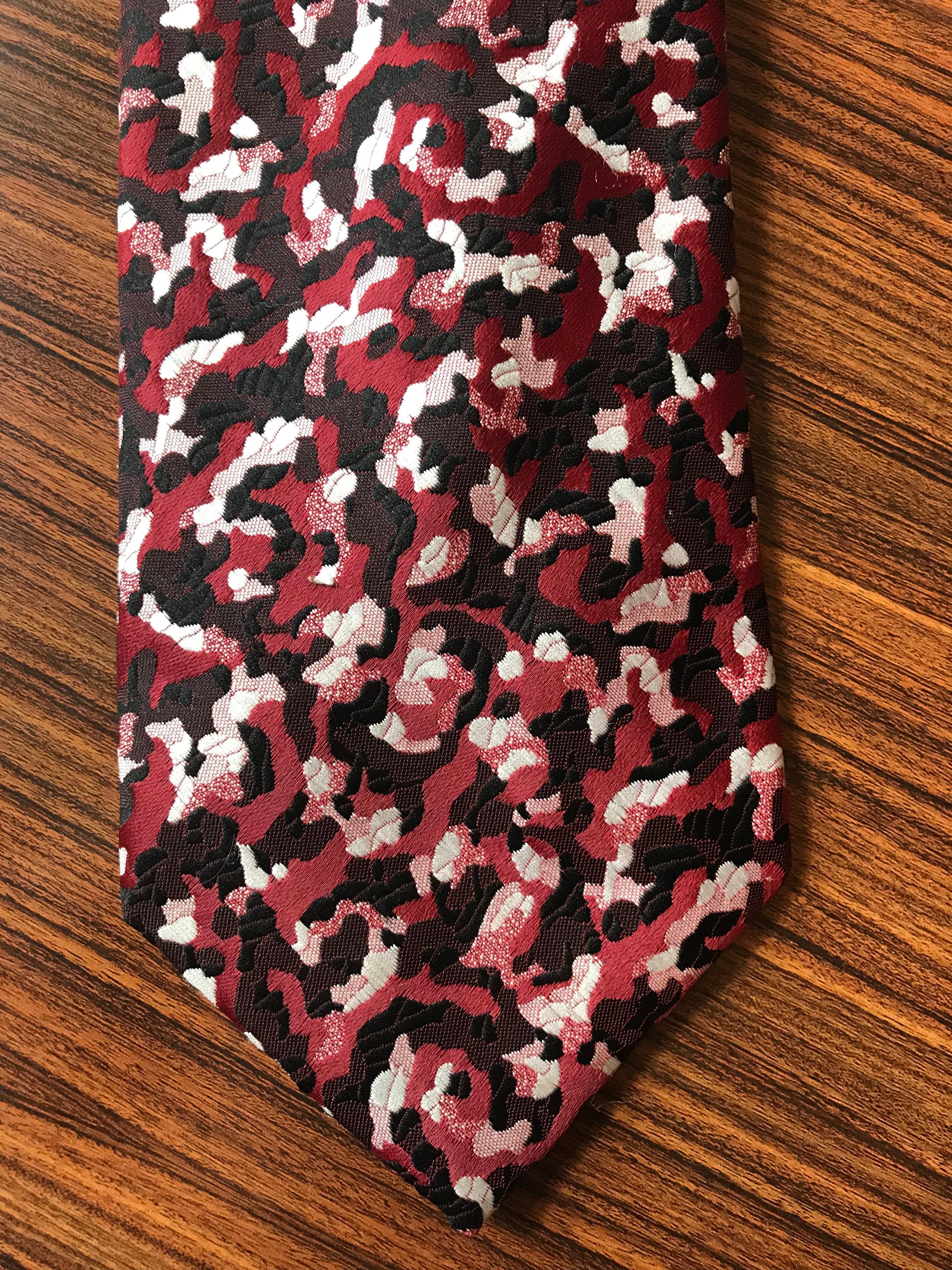 Schiaparelli 1970s tie in a beautiful red (the color of a fresh ripe cherry) black and white pattern created for the now defunct Michigan department store Hughes & Hatcher. Signed Schiaparelli at label and throughout lining.

Measures 4 1/4