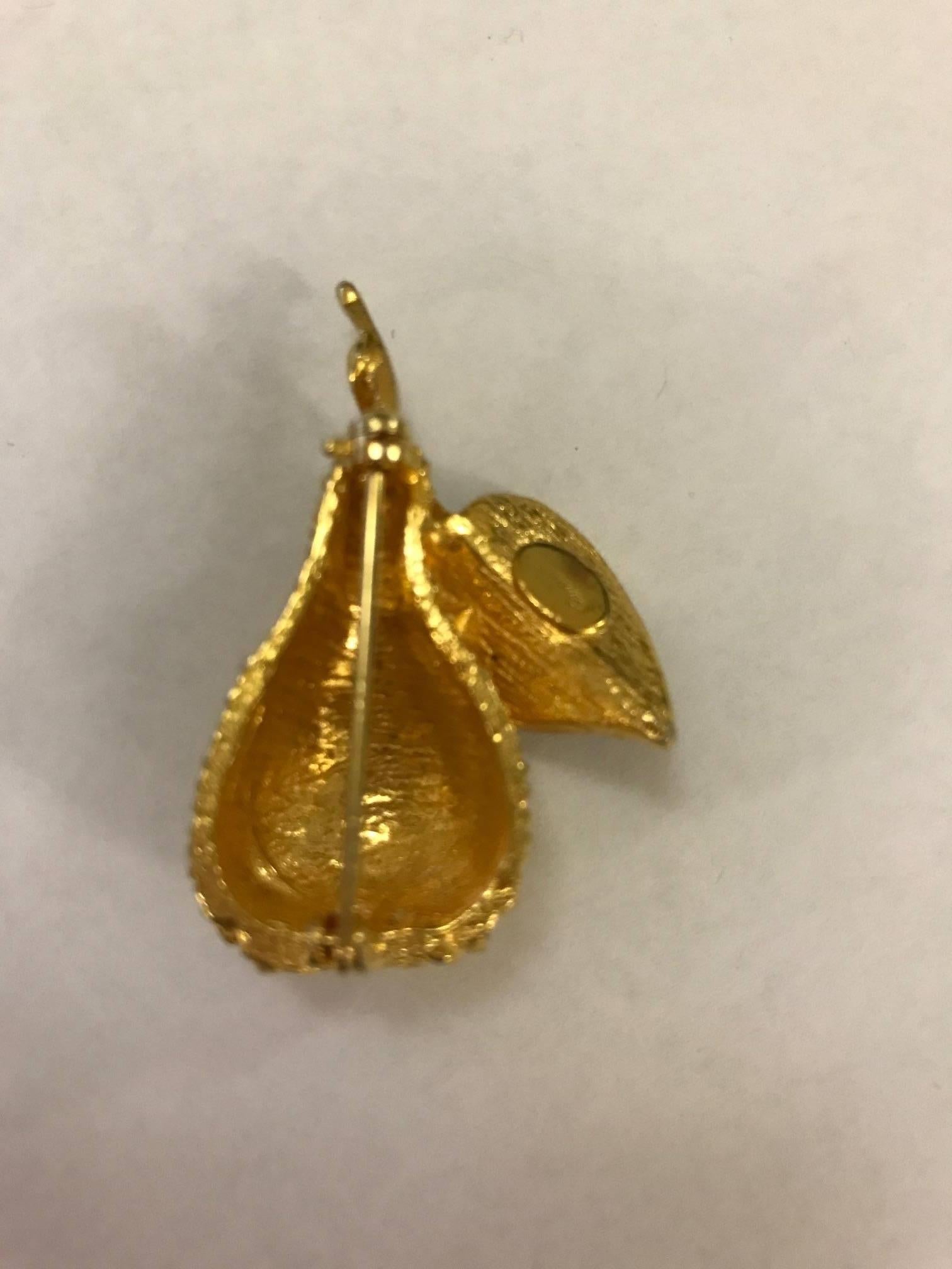 Gold tone Hattie Carnegie costume jewelry brooch featuring a gold pear with faux onyx cabochon embellishments on the leaf. 

Approximately 1 3/4" x 1 1/2".
Signed 'Carnegie' at back, final letters of signature have faded.

Excellent