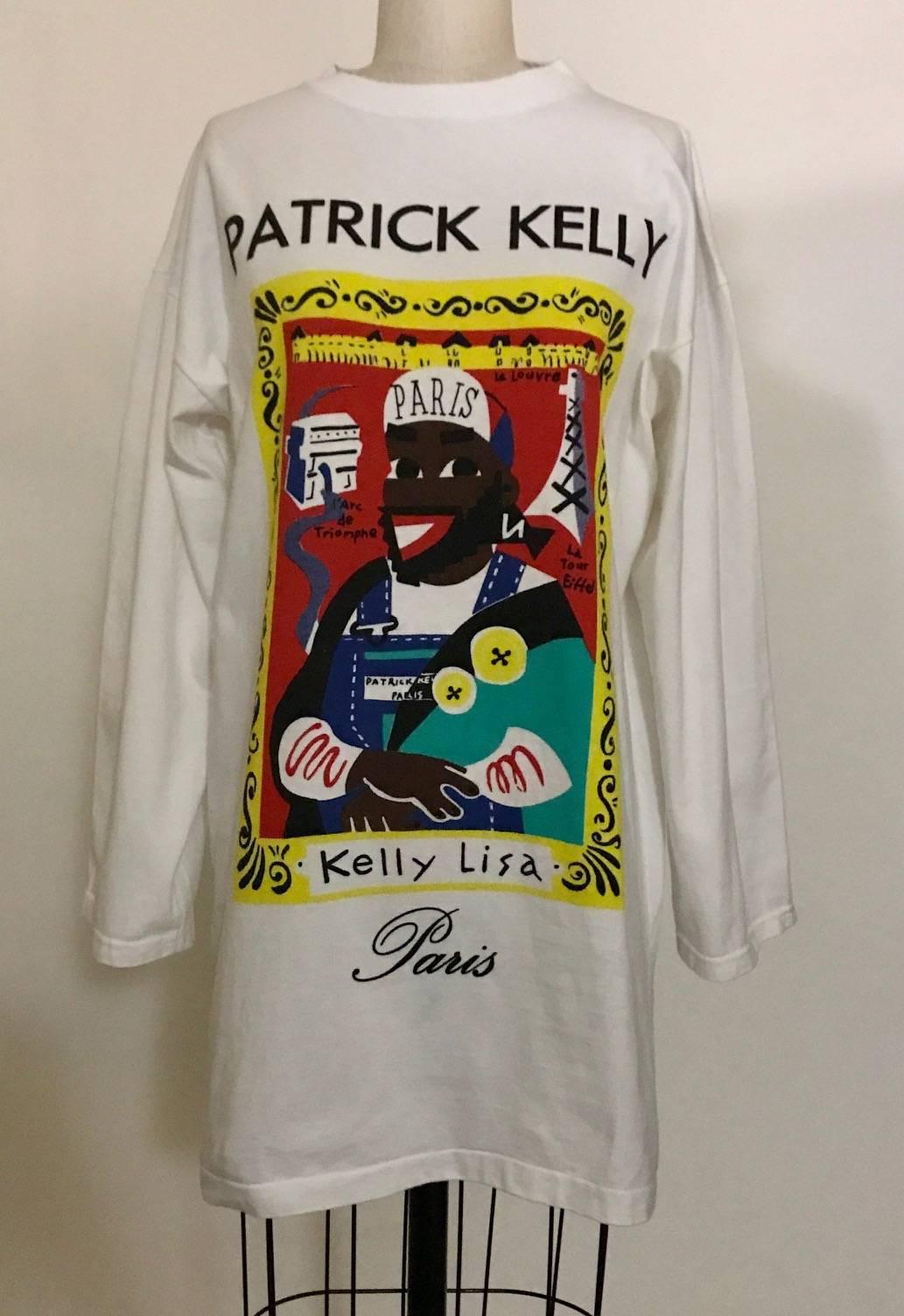 Patrick Kelly oversized white t-shirt from 1988 featuring Patrick Kelly as the Mona Lisa. Doodle shows Patrick in his signature Paris hat with the Eiffel Tower in the background and even sporting his trademark buttons. Drop shoulder with long, not