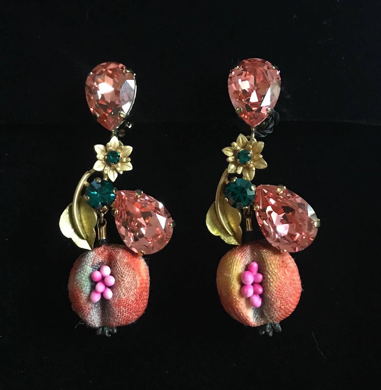 Dolce & Gabbana gold tone clip on earrings with cloth covered pomegranates featuring tiny seeds and pink and green crystal accents, along with a tiny gold flower and leaf. 

Approximately 3