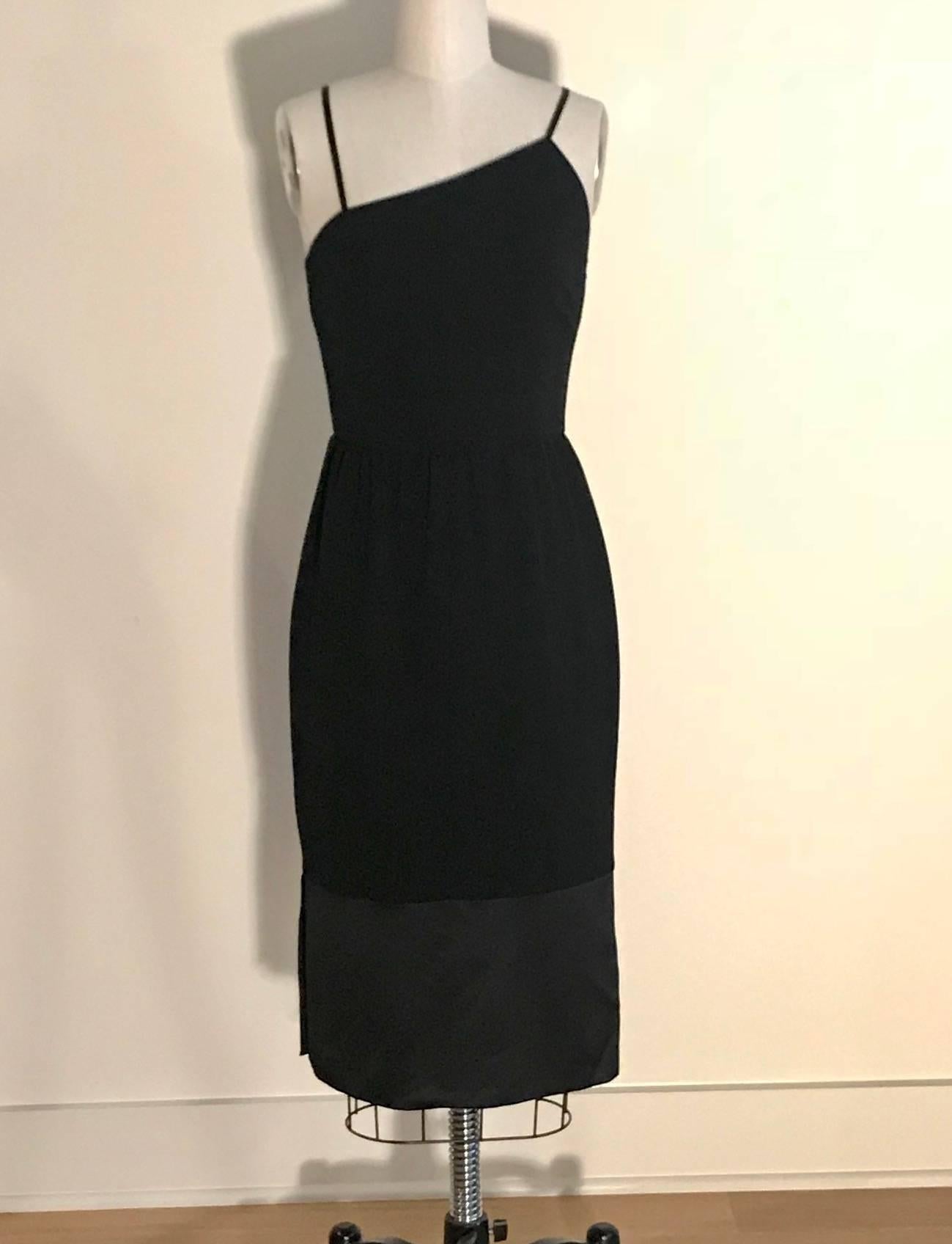 Chanel Boutique vintage little black dress from the 1998 Pre-Fall Collection. Asymmetrical cut at chest gives a classic black Chanel staple a bit of unexpected flare. Gathered waist. Silk straps and hem detail. Back zip and hook and eye with black