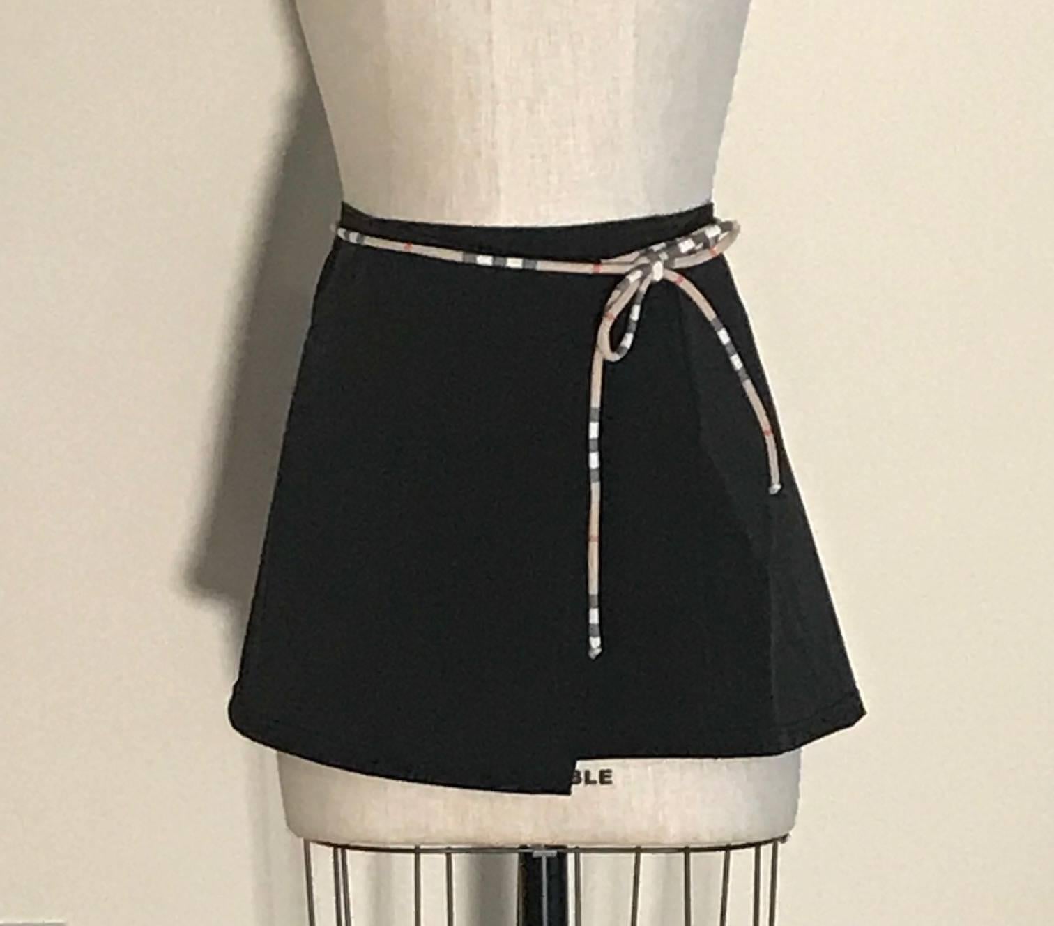 New with tags Burberry London little black wrap skirt for over your swimming suit at the pool or beach. Fastens with signature Burberry tan, black, and red plaid tie.

80% polyamide, 20% elastane.

Made in Italy.

Size M (slightly adjustable due to