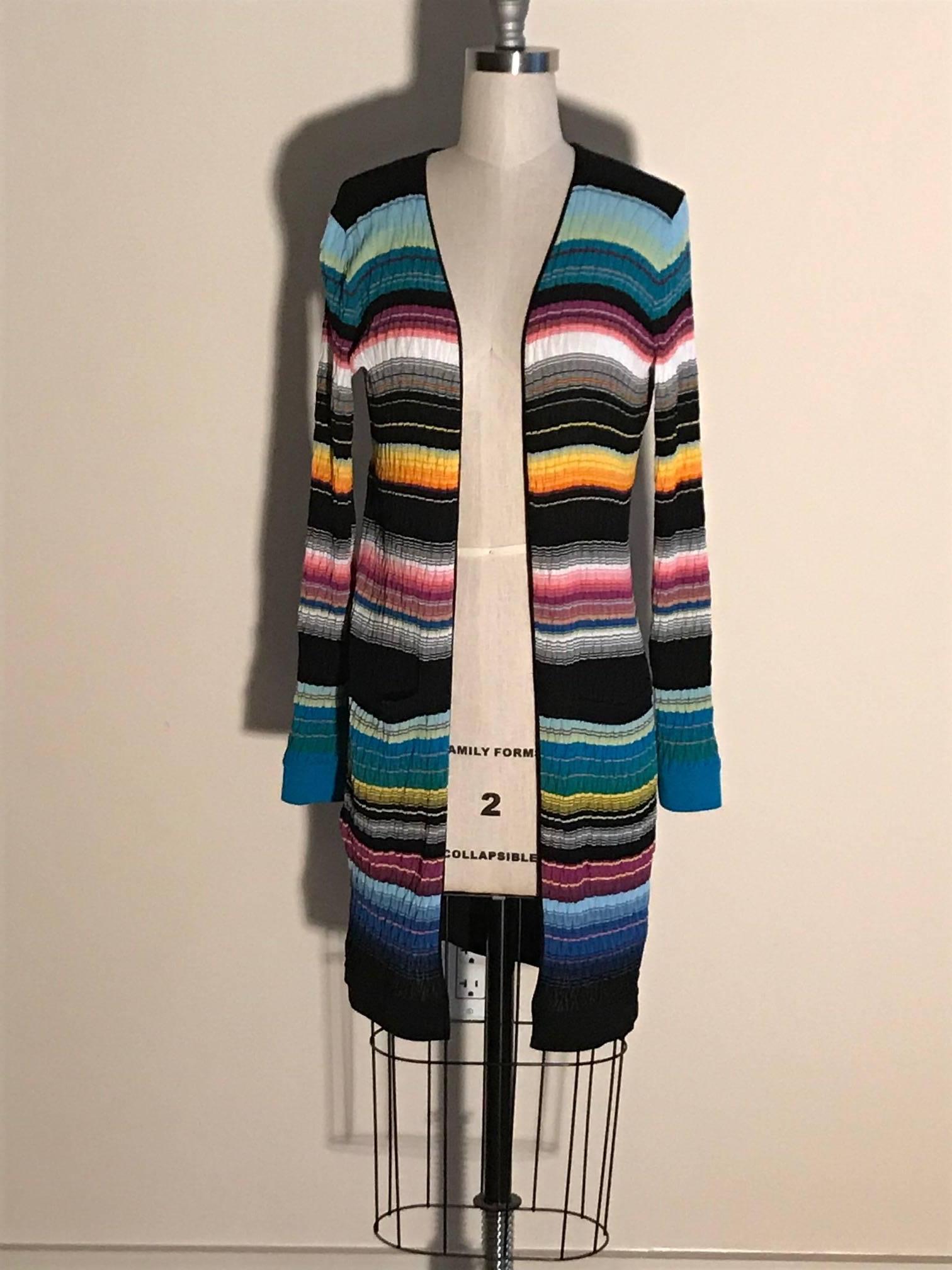 Missoni stripe knit long sleeve sweater with varying shades of teal, fuchsia, goldenrod, black, and cream.  Textured with a chevron pattern ribbing. Pockets at both sides of front hip. Open front, no fasteners. 

67% cotton, 31% rayon, 2%