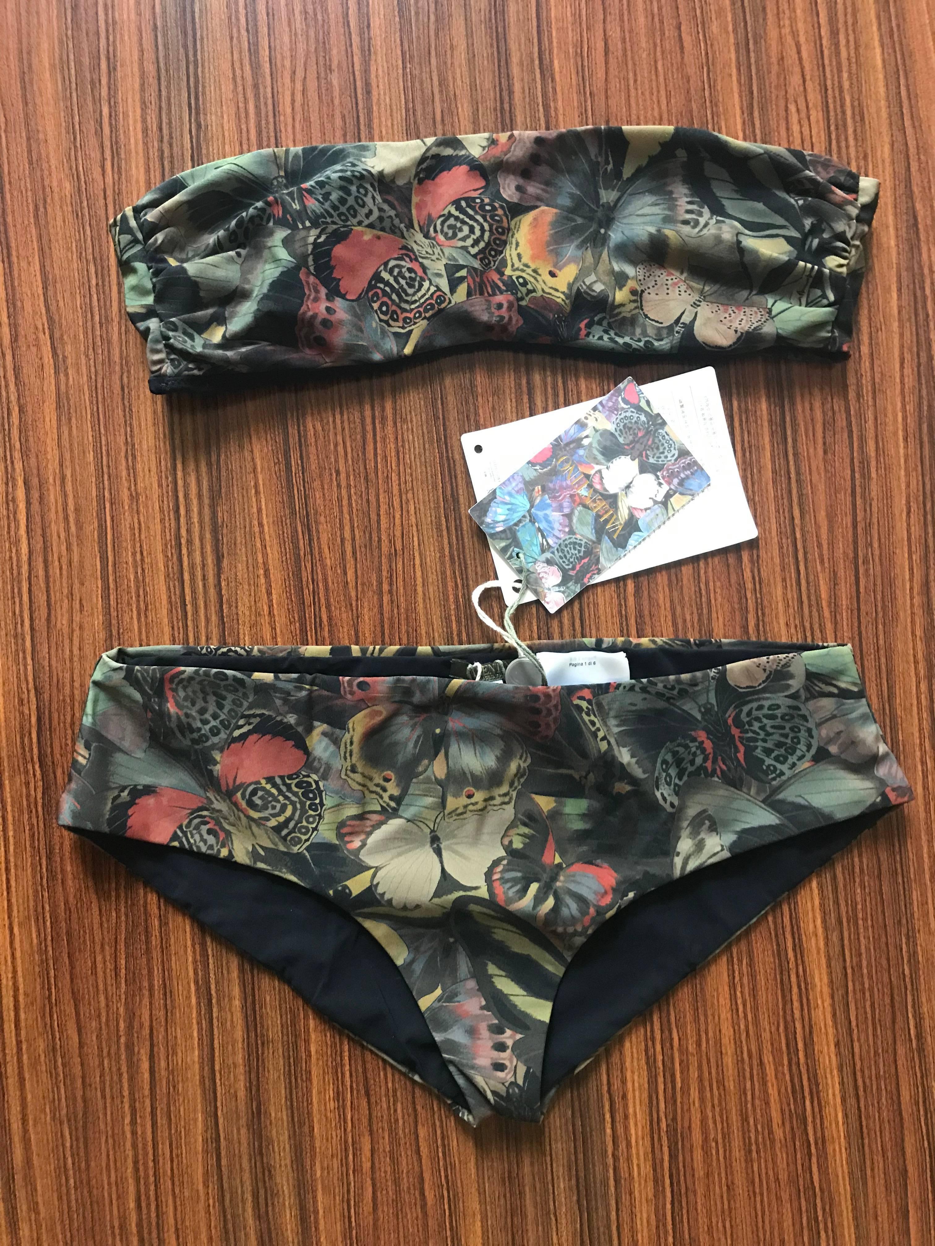 New with tags Valentino green and multicolor butterfly print bikini bathing suit with bandeau top. Butterfly print is from a collage created by artist Marlies Plank. Gold Valentino rock stud closure fastens at back of swim suit top.   

72%