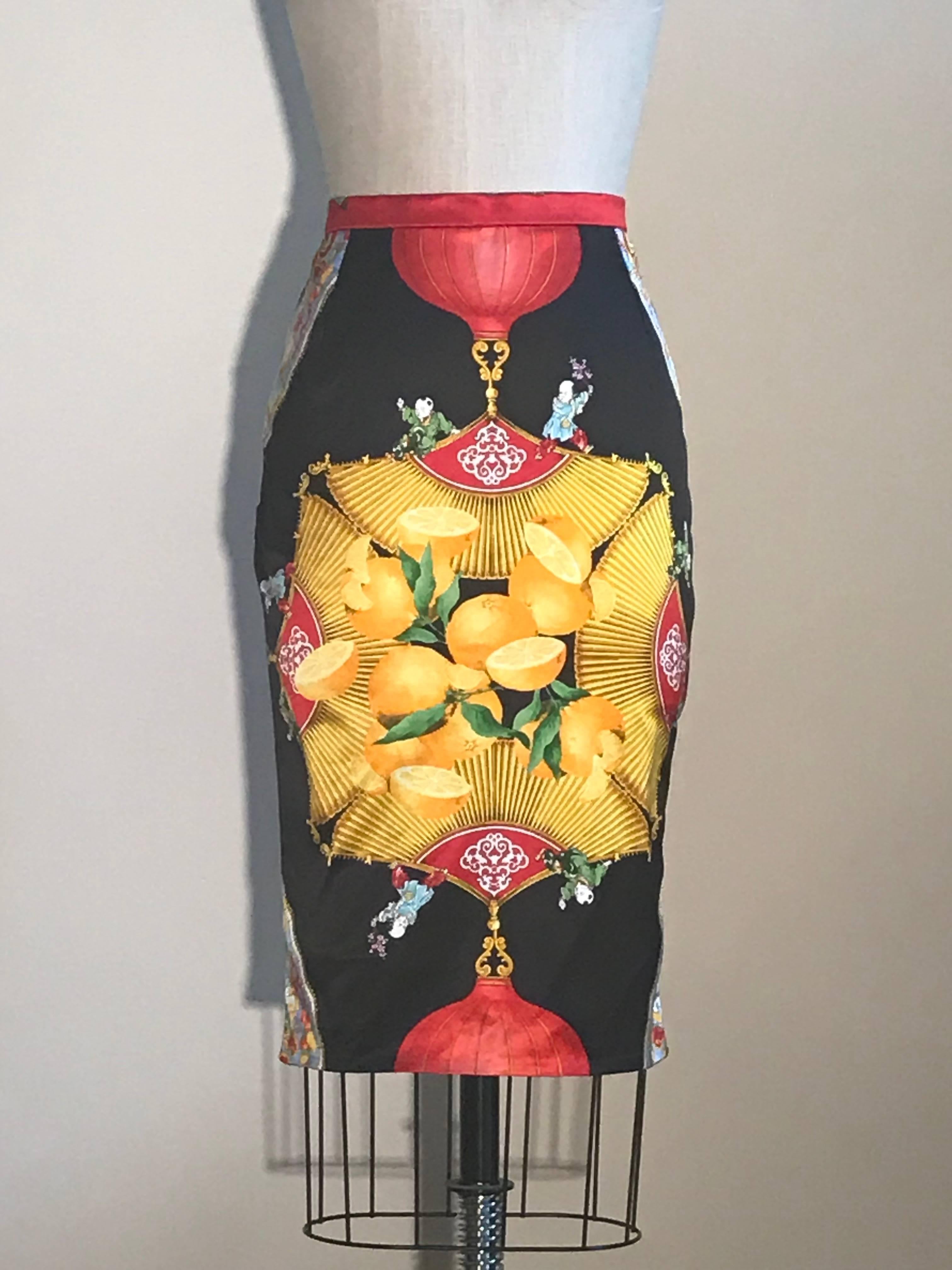 Very rare Dolce & Gabbana 1990s pencil skirt in a whimsical Oriental inspired print featuring citrus fruit, fans, lanterns, tassels, and small frolicking robed men. Back zip and snap.

No content label, most likely a silk polyamide elastane