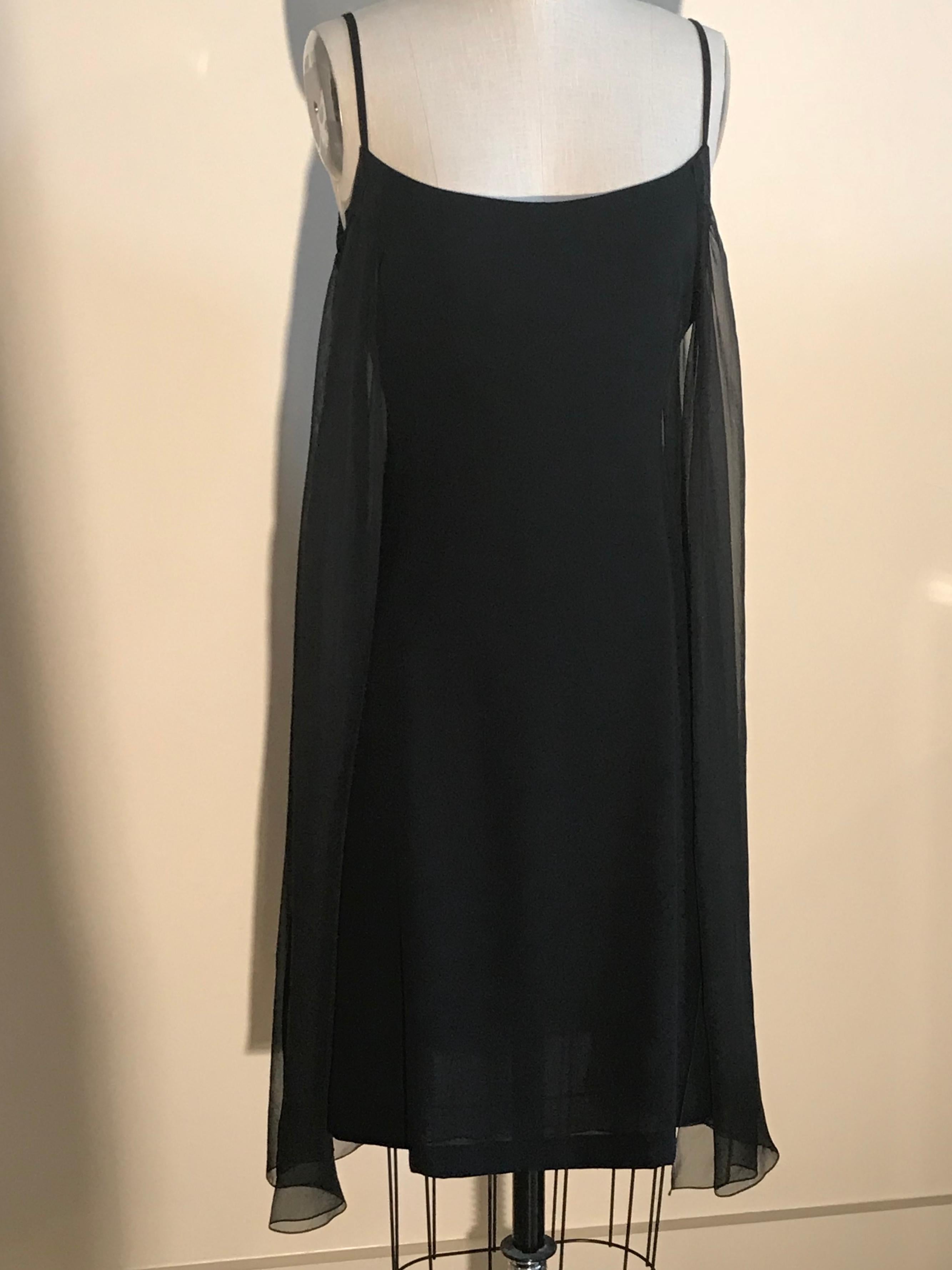 Chanel little black silk dress from the 2001 collection. Draped sheer silk chiffon panels cascade at sides. Small black metal CC logo at side bust. Thin straps, back zip and hook and eye closure. 

100% silk.

Made in France.

Labelled size French