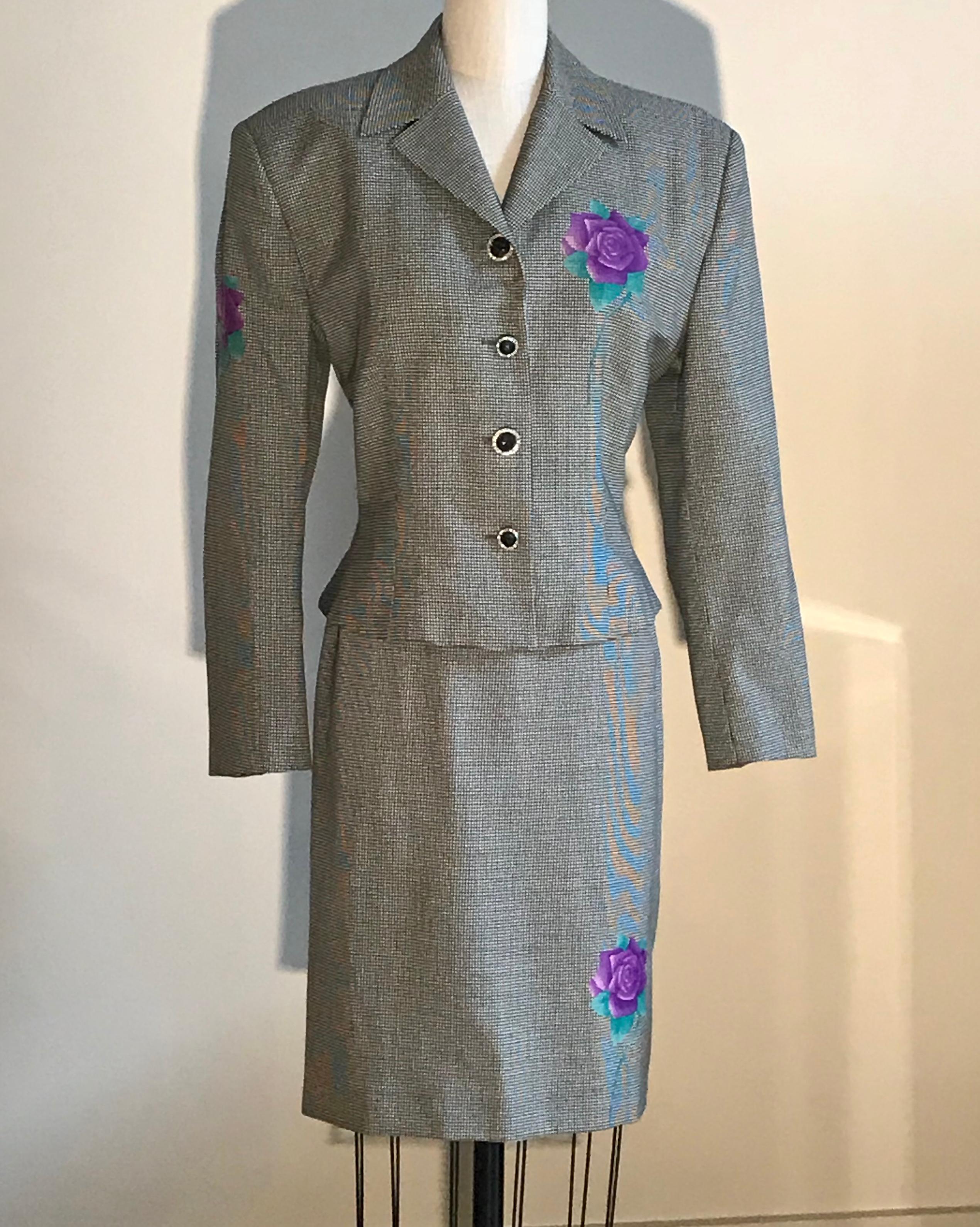 Gianni Versace vintage wool skirt suit in black and white houndstooth or dogtooth check. Purple and green roses printed at jacket bust, one sleeve, and back, as well as on front and back skirt. Jacket features purple Versace logo buttons with