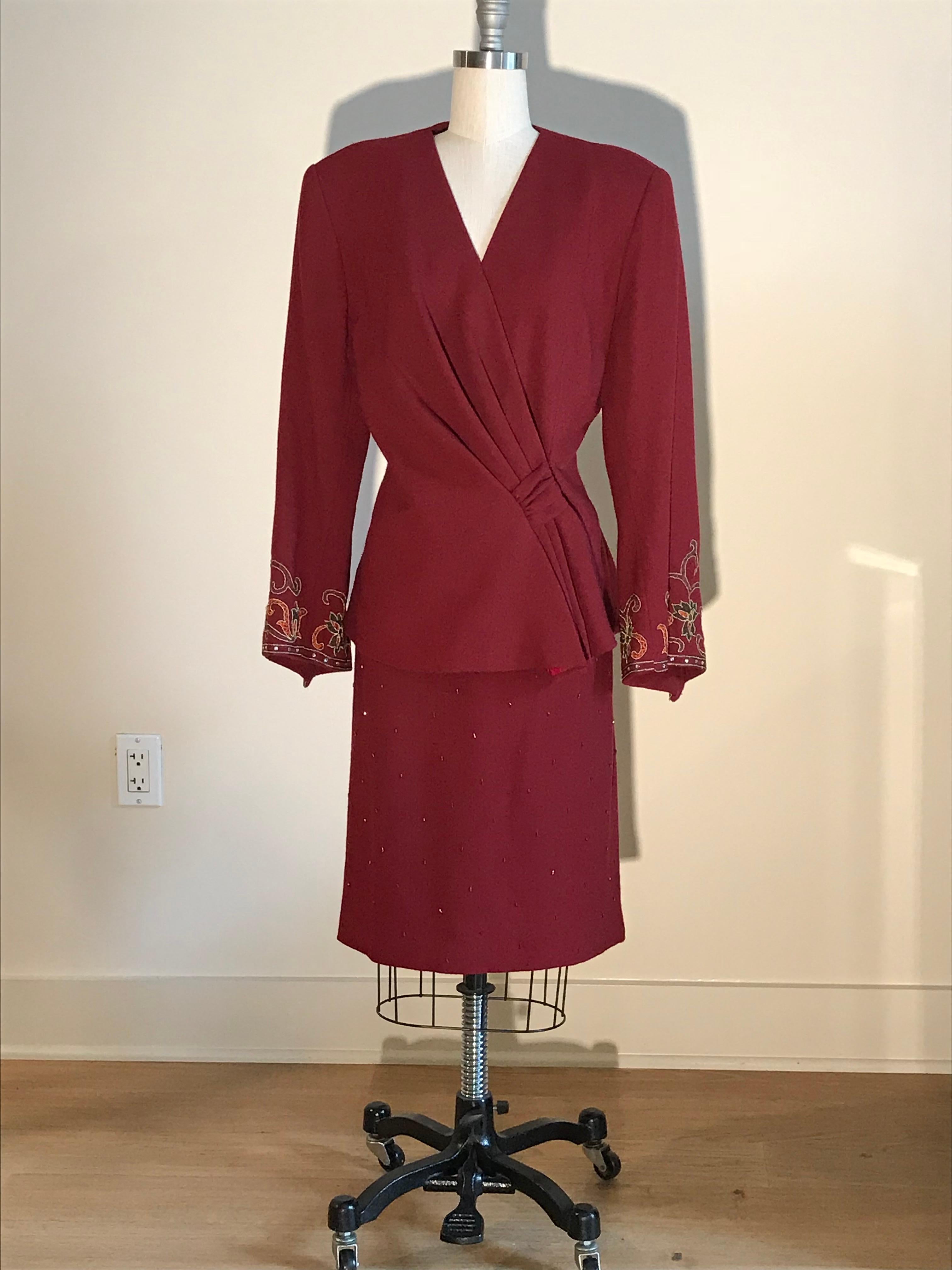 Pierre Balmain vintage 1980s cranberry red wool skirt suit featuring beading at skirt at embroidery and rhinestone embellishment at diagonally hemmed sleeves. Skirt has back zip, jacket fastens with a snap and two hook and thread closures.

100%